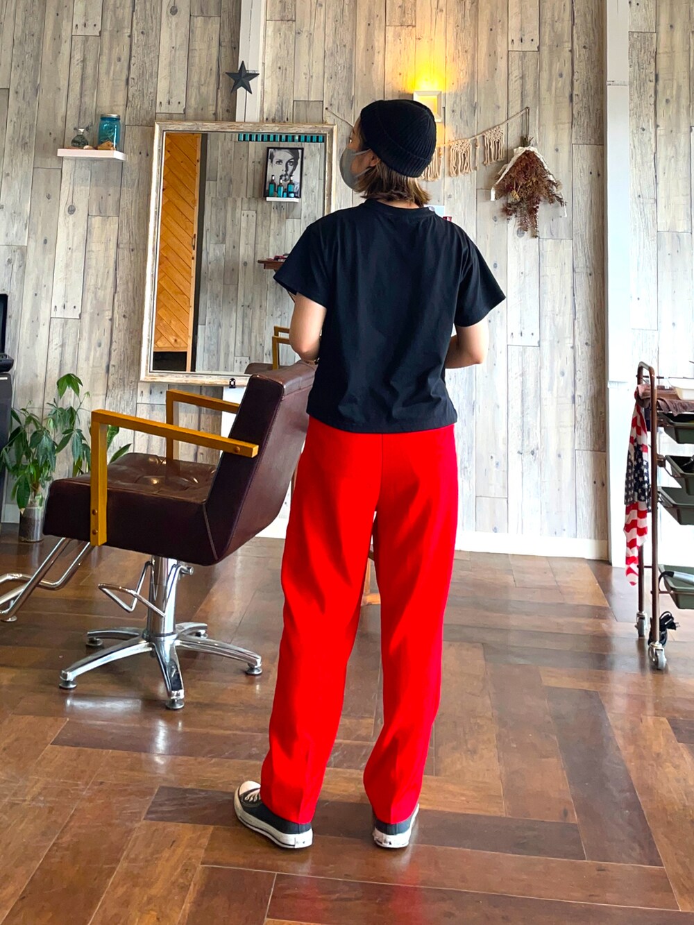 レッド系のスラックス、ブラック系のTシャツ/カットソー、ブラック系のスニーカーを着用したレディースの夏コーディネートの2枚目の写真