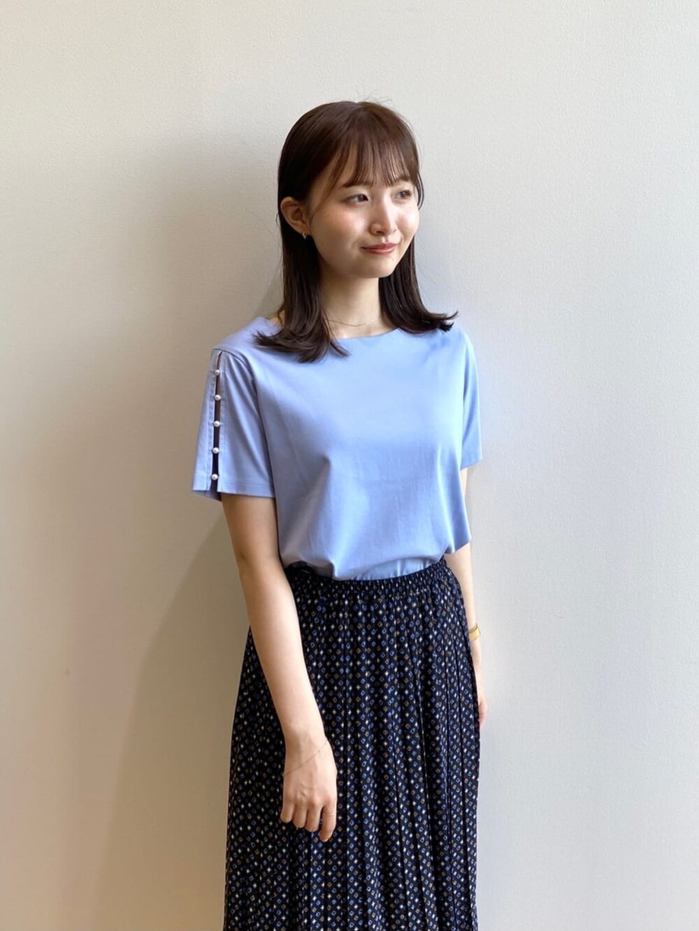 ブラック系のスカート、ブルー系のTシャツ/カットソー、ブラック系のサンダルを着用したレディースの夏コーディネートの4枚目の写真