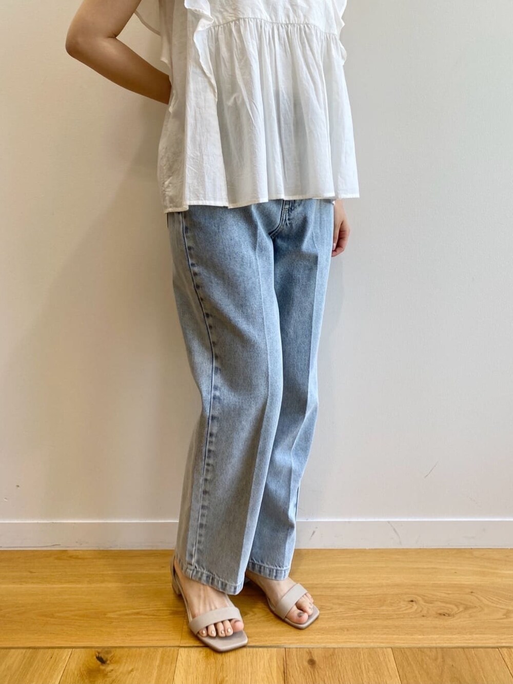 ブルー系のデニムパンツ、ベージュ系のサンダル、ホワイト系のシャツ/ブラウスを着用したレディースの夏コーディネートの9枚目の写真