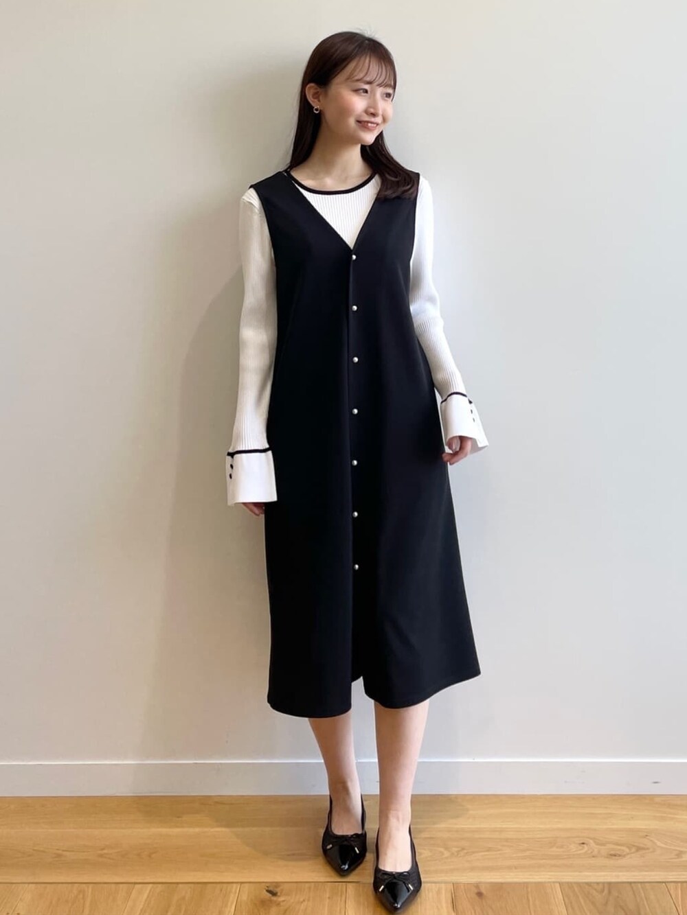 ホワイト系のニット/セーター、ブラック系のスカート、ブラック系のその他シューズを着用したレディースの春コーディネートの2枚目の写真