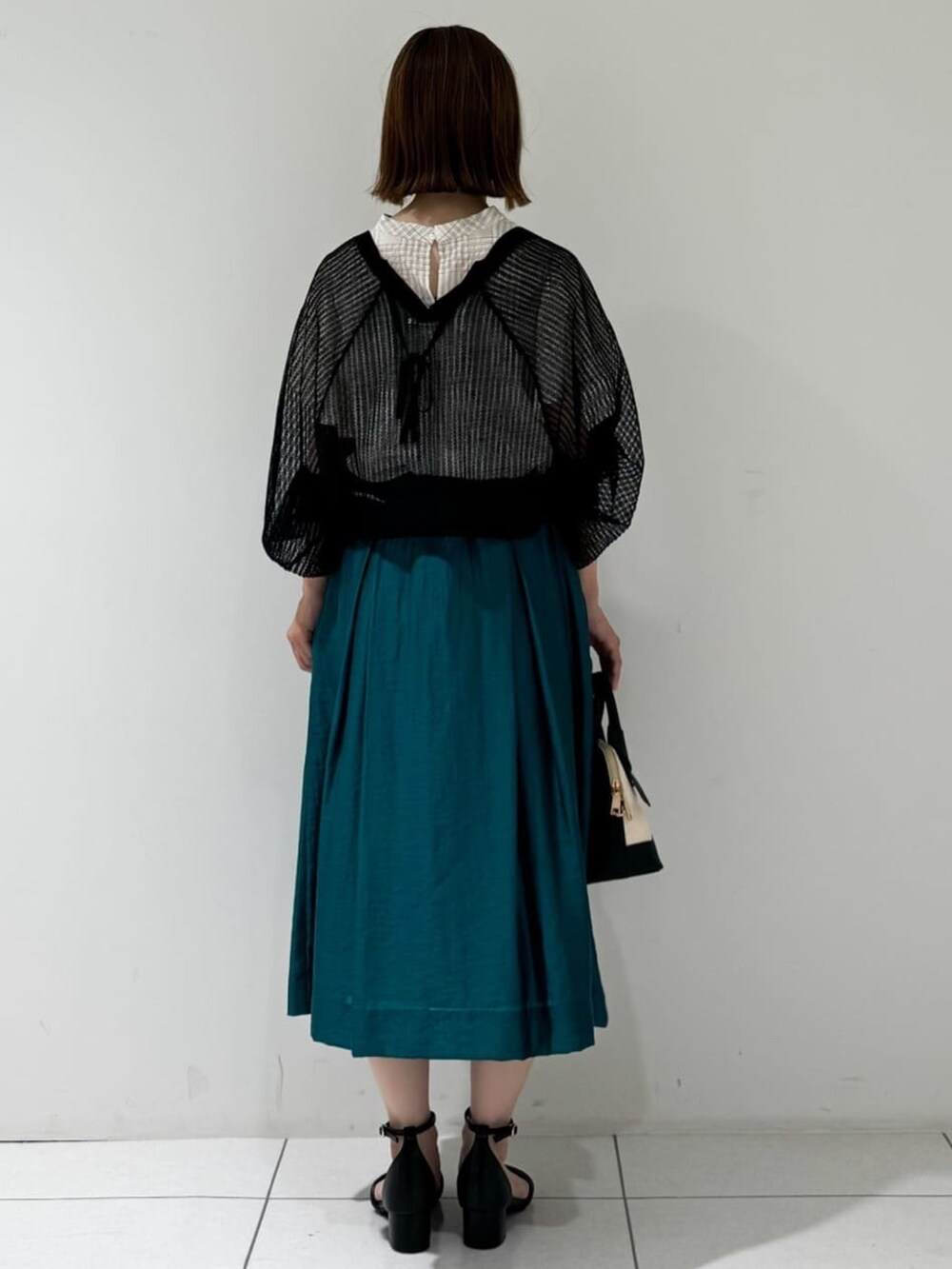 ブラック系のカーディガン/ボレロ、ベージュ系のシャツ/ブラウス、グリーン系のスカートを着用したレディースの夏コーディネートの3枚目の写真