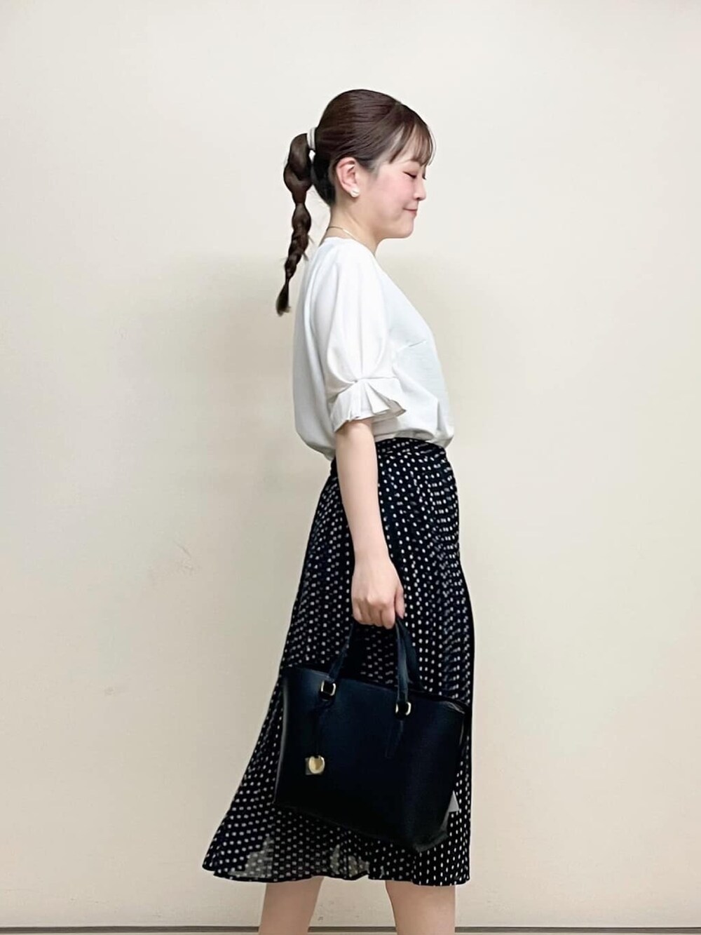 ホワイト系のシャツ/ブラウス、ブラック系のスカート、ブラック系のトートバッグを着用したレディースの春コーディネートの3枚目の写真