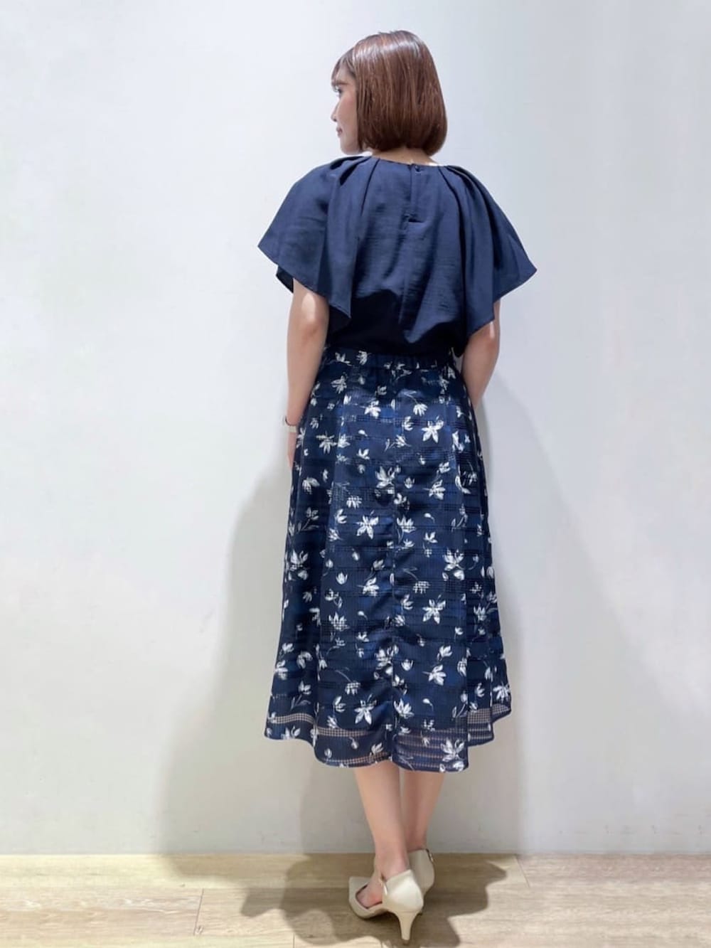 ブルー系のシャツ/ブラウス、ブルー系のスカート、ベージュ系のパンプスを着用したレディースの夏コーディネートの3枚目の写真