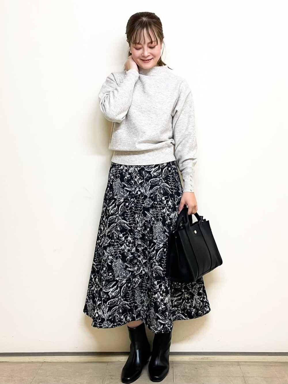 ベージュ系のニット/セーター、ブラック系のスカート、ブラック系のトートバッグを着用したレディースの冬コーディネートの5枚目の写真