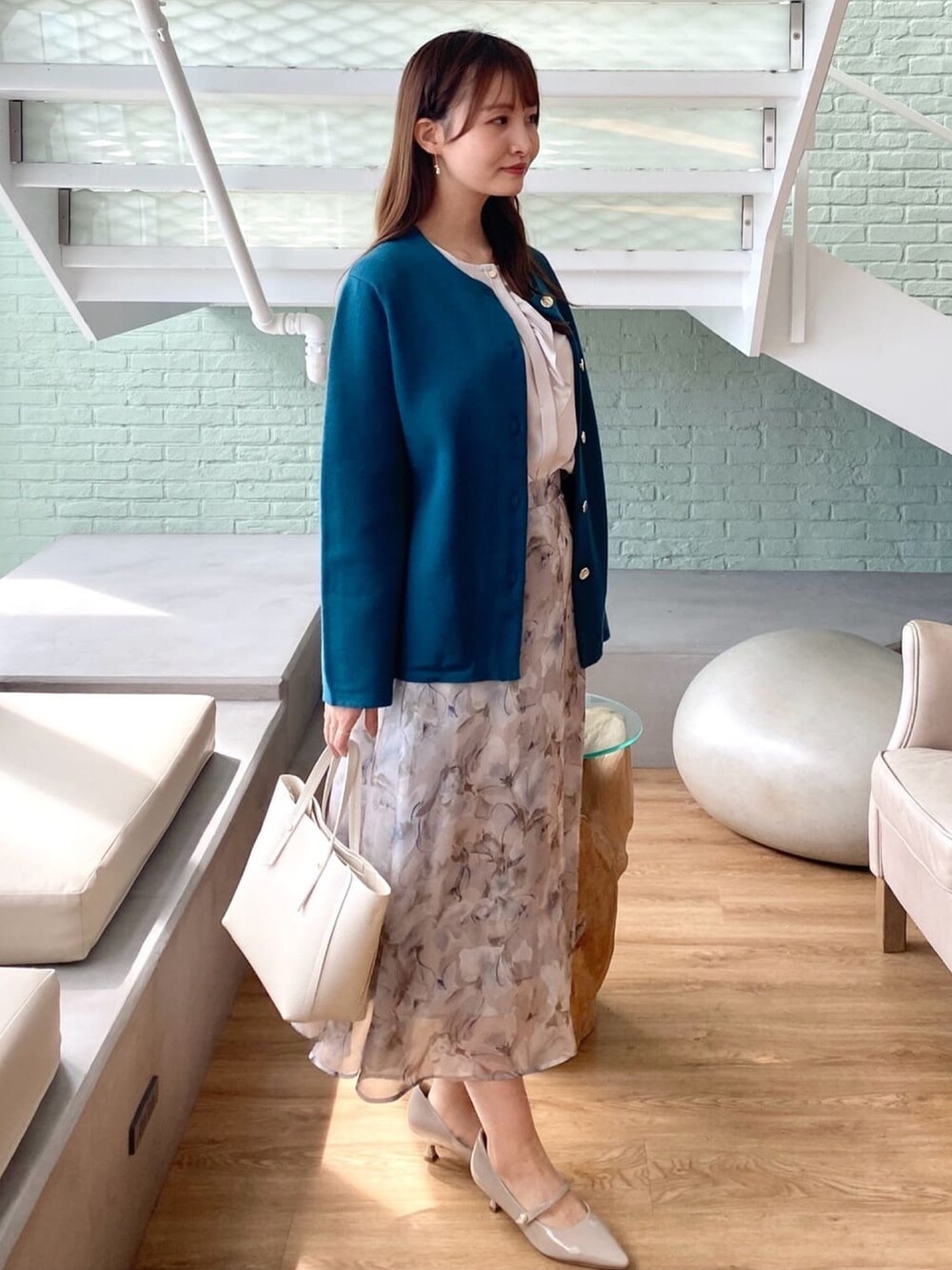 ブルー系のカーディガン/ボレロ、ベージュ系のシャツ/ブラウス、グレー系のスカートを着用したレディースの秋コーディネートの3枚目の写真