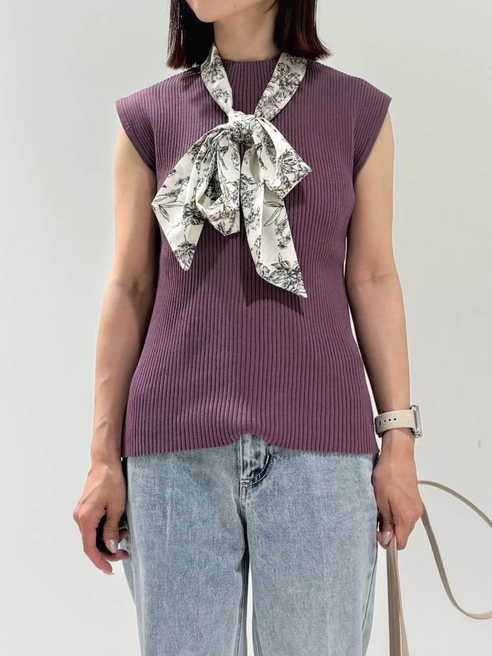 パープル系のニット/セーター、ベージュ系のショルダーバッグ、ブルー系のデニムパンツを着用したレディースの夏コーディネートの4枚目の写真