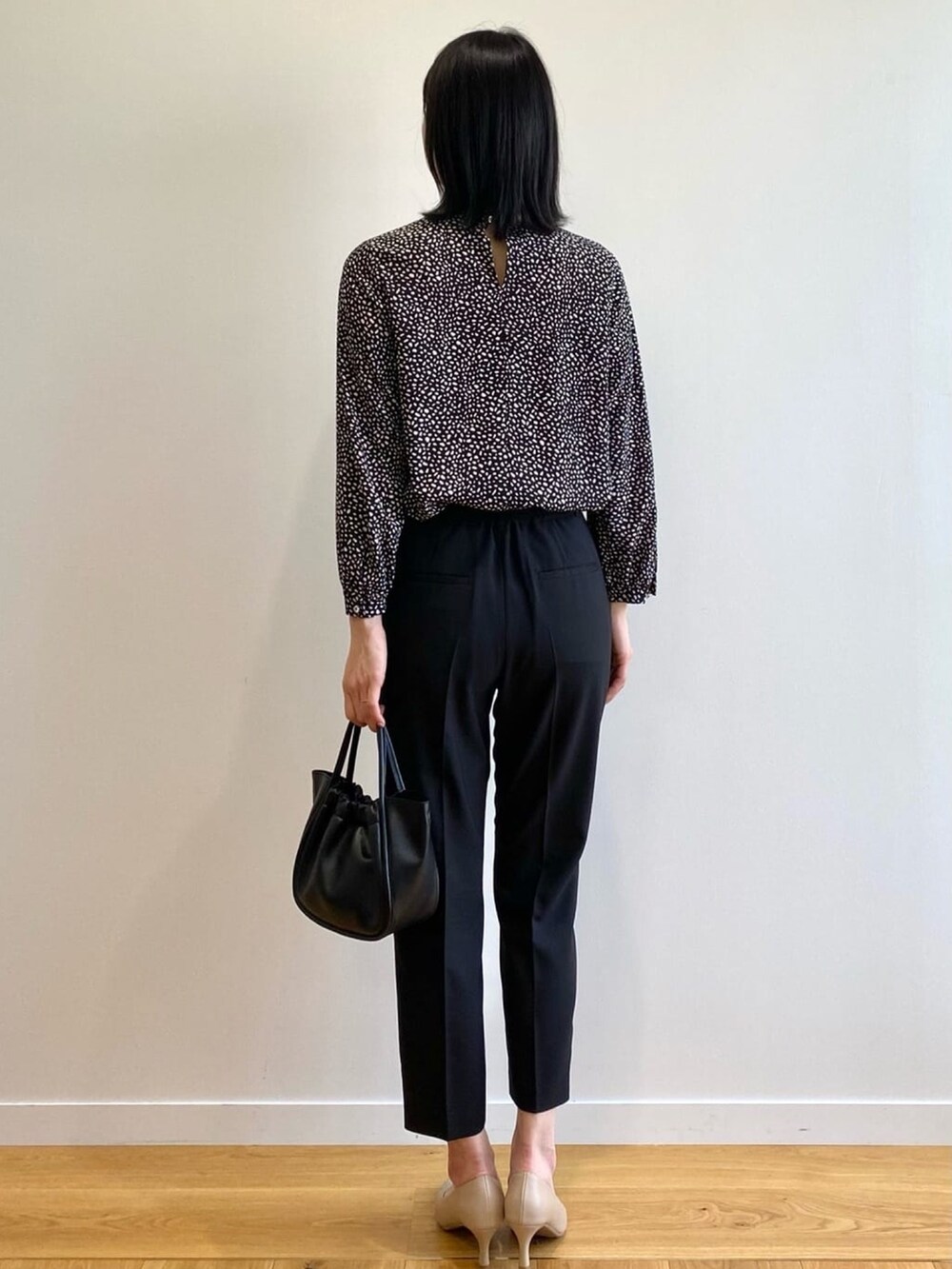 ブラック系のトートバッグ、ベージュ系のパンプス、ブラック系のその他パンツを着用したレディースの春コーディネートの3枚目の写真