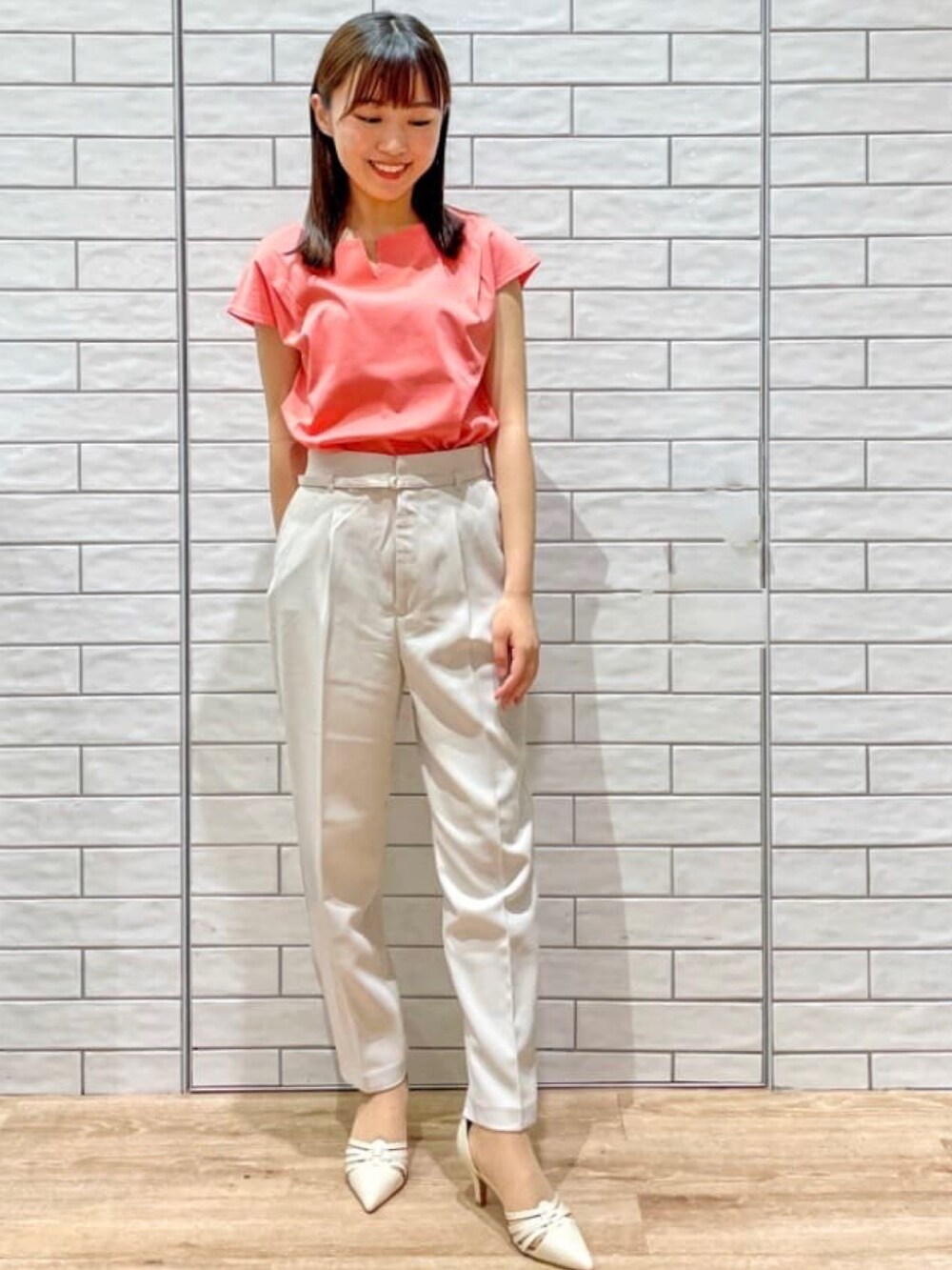オレンジ系のTシャツ/カットソー、ベージュ系のその他パンツ、ホワイト系のパンプスを着用したレディースの夏コーディネートの2枚目の写真