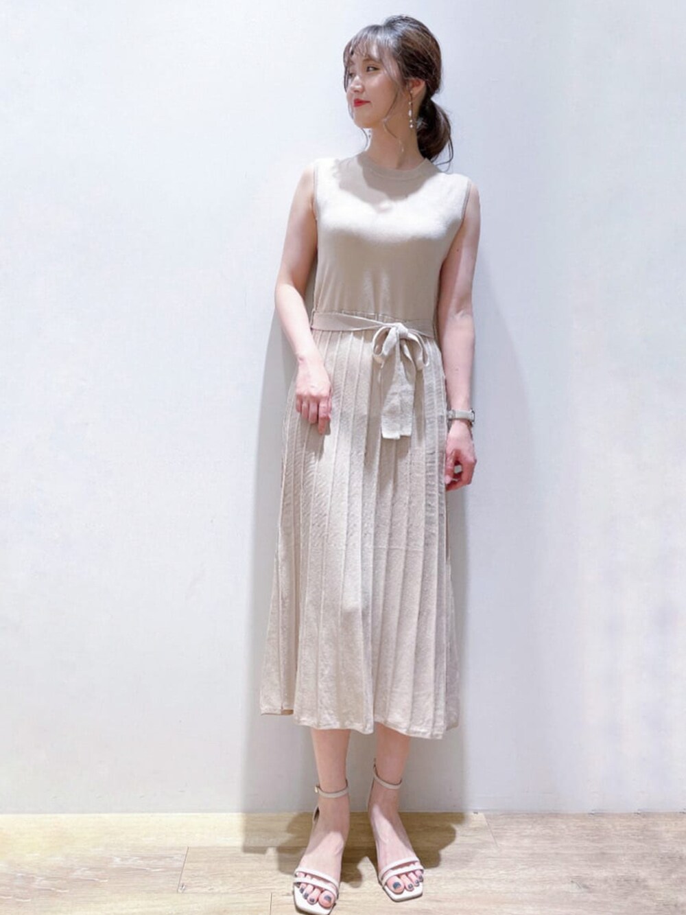 ホワイト系のワンピース、ベージュ系のサンダル、ホワイト系のイヤリングを着用したレディースの夏コーディネートの2枚目の写真