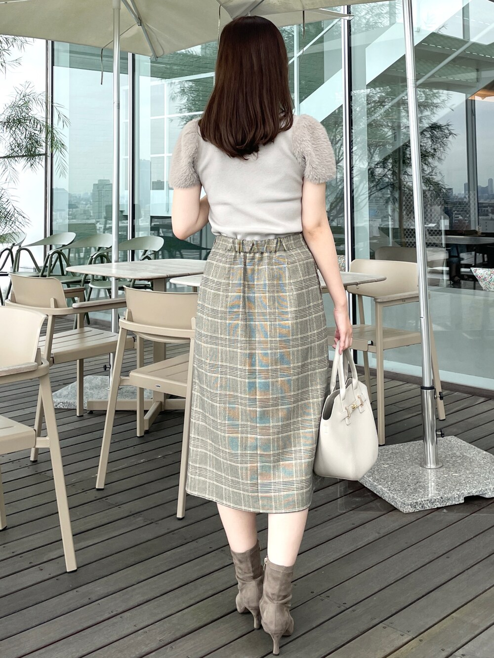 ベージュ系のスカート、ベージュ系のニット/セーター、ベージュ系のトートバッグを着用したレディースの夏コーディネートの3枚目の写真