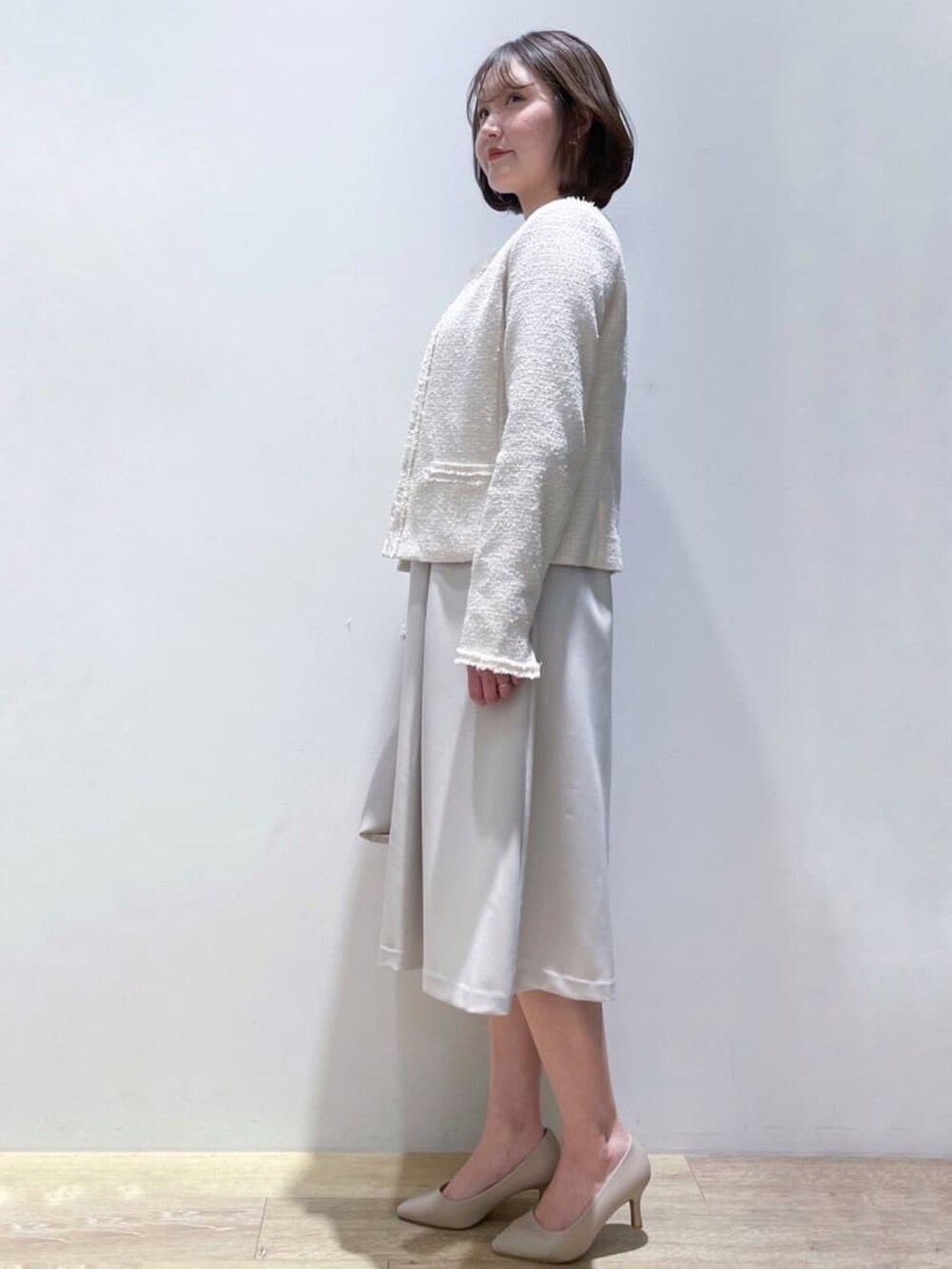 ベージュ系のワンピース、グレー系のショルダーバッグ、ベージュ系のパンプスを着用したレディースの冬コーディネートの2枚目の写真