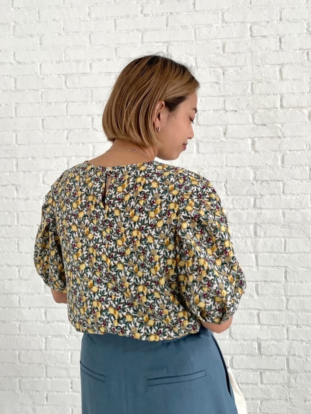 ブルー系のその他パンツ、ホワイト系のサンダル、ホワイト系のシャツ/ブラウスを着用したレディースの夏コーディネートの3枚目の写真