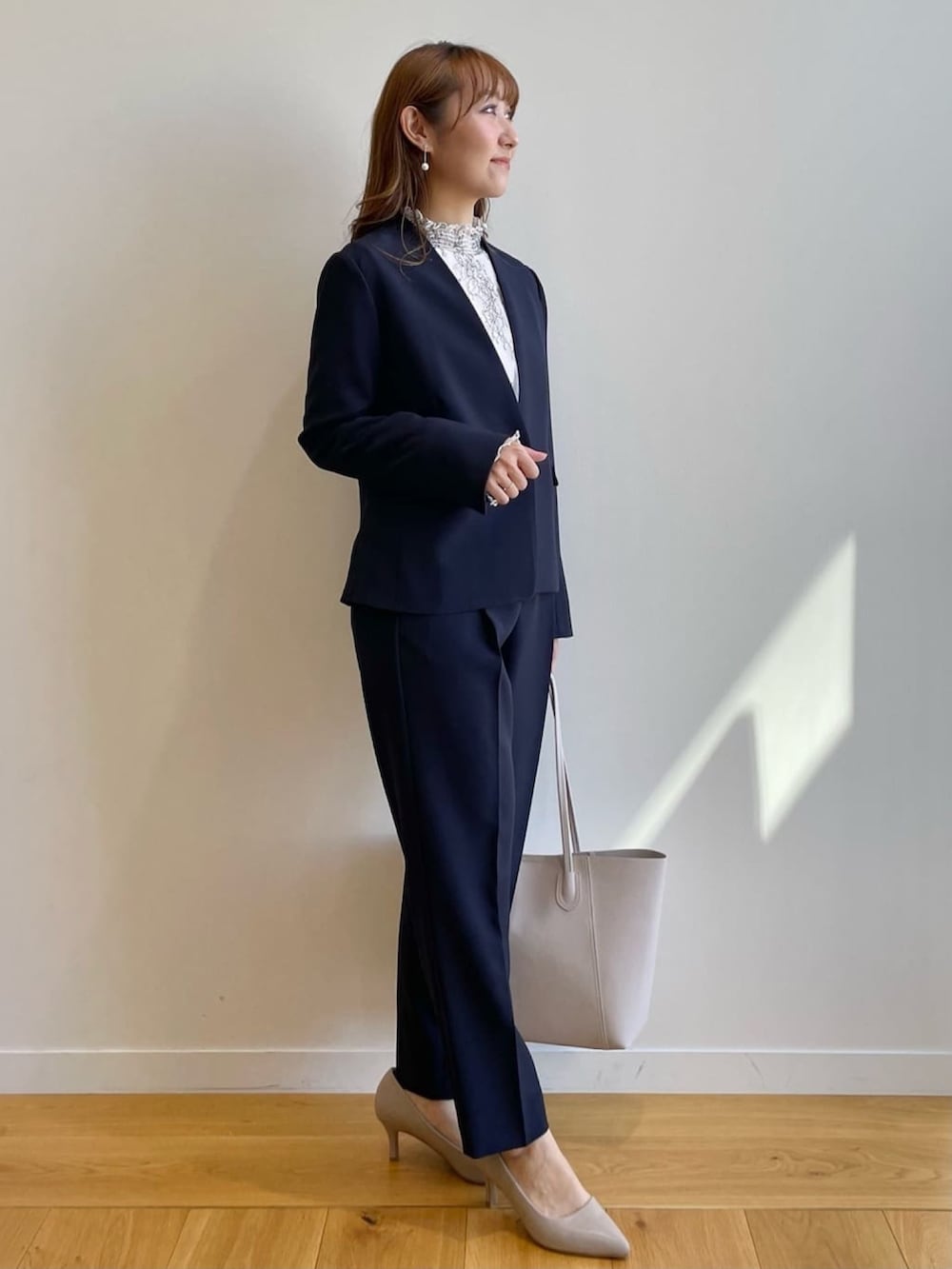 ブルー系のノーカラージャケット、ブルー系のその他パンツ、ベージュ系のTシャツ/カットソーを着用したレディースの冬コーディネートの2枚目の写真