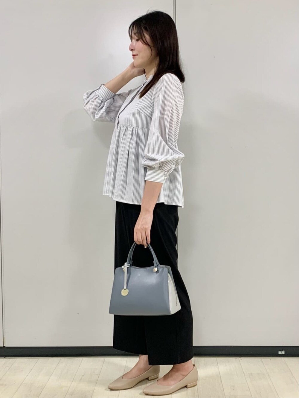 ホワイト系のシャツ/ブラウス、ブラック系のその他パンツ、ブルー系のボストンバッグを着用したレディースの秋コーディネートの2枚目の写真