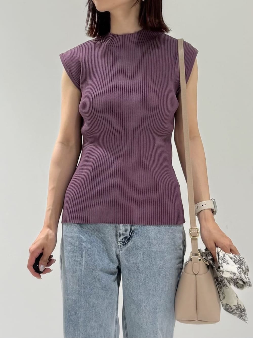 パープル系のニット/セーター、ベージュ系のショルダーバッグ、ブルー系のデニムパンツを着用したレディースの夏コーディネートの5枚目の写真