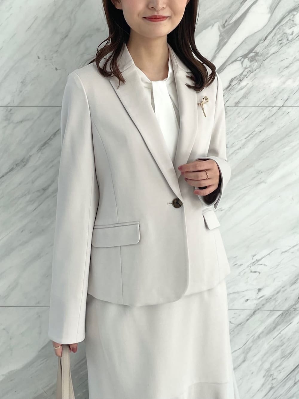 グレー系のスカート、ベージュ系のトートバッグ、ホワイト系のシャツ/ブラウスを着用したレディースの冬コーディネートの4枚目の写真