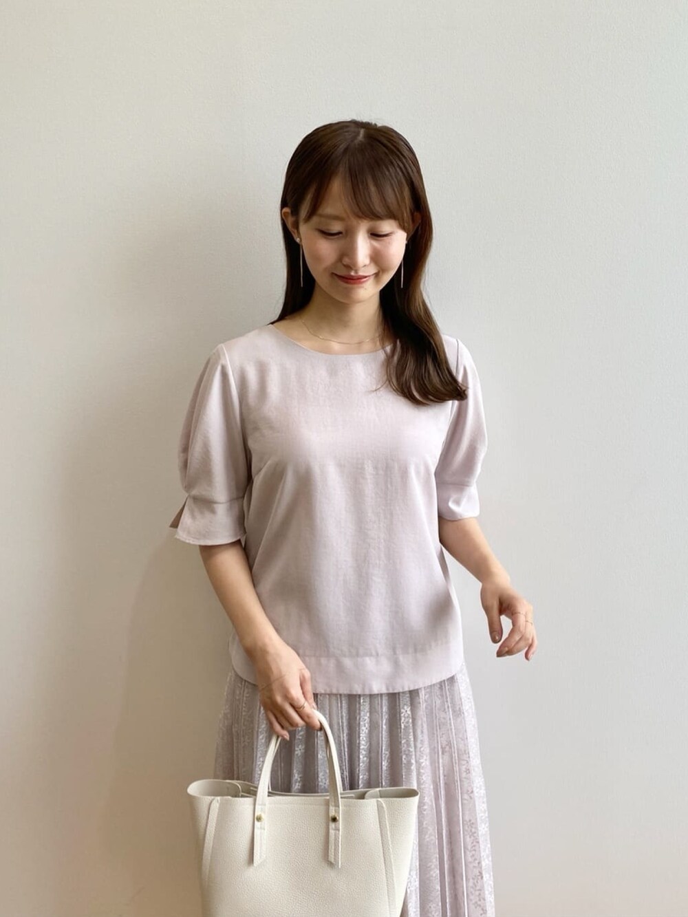 ベージュ系のシャツ/ブラウス、ベージュ系のスカート、ホワイト系のトートバッグを着用したレディースの夏コーディネートの7枚目の写真