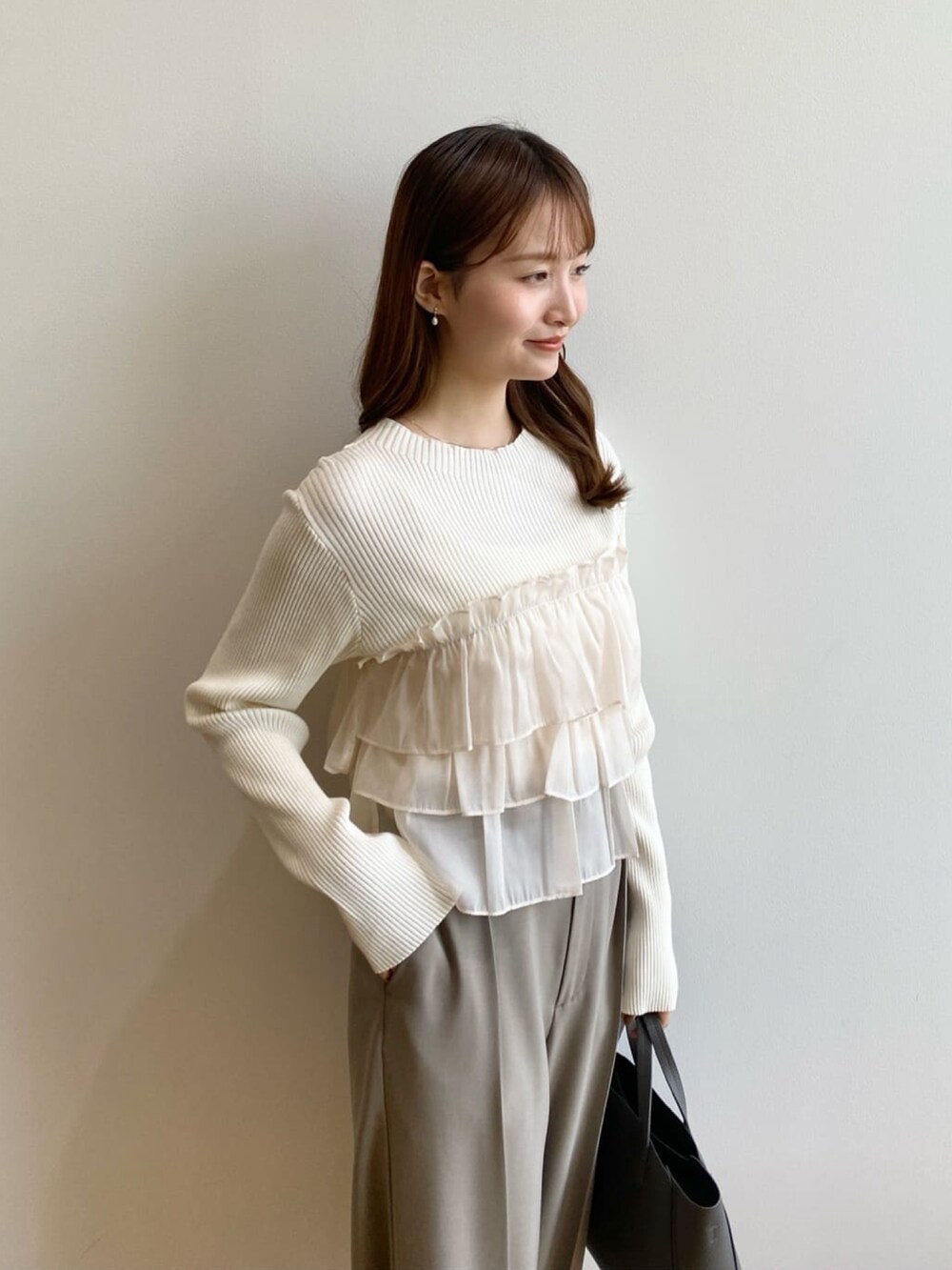 ホワイト系のニット/セーター、ベージュ系のその他パンツ、グレー系のトートバッグを着用したレディースの秋コーディネートの7枚目の写真