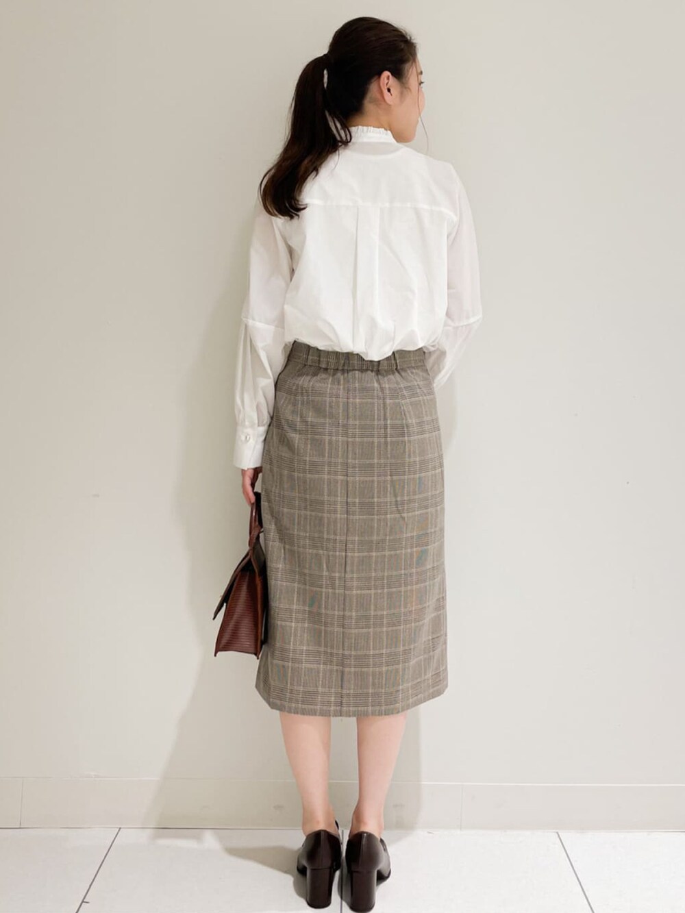 ホワイト系のシャツ/ブラウス、ベージュ系のスカート、ブラウン系のショルダーバッグを着用したレディースの秋コーディネートの3枚目の写真