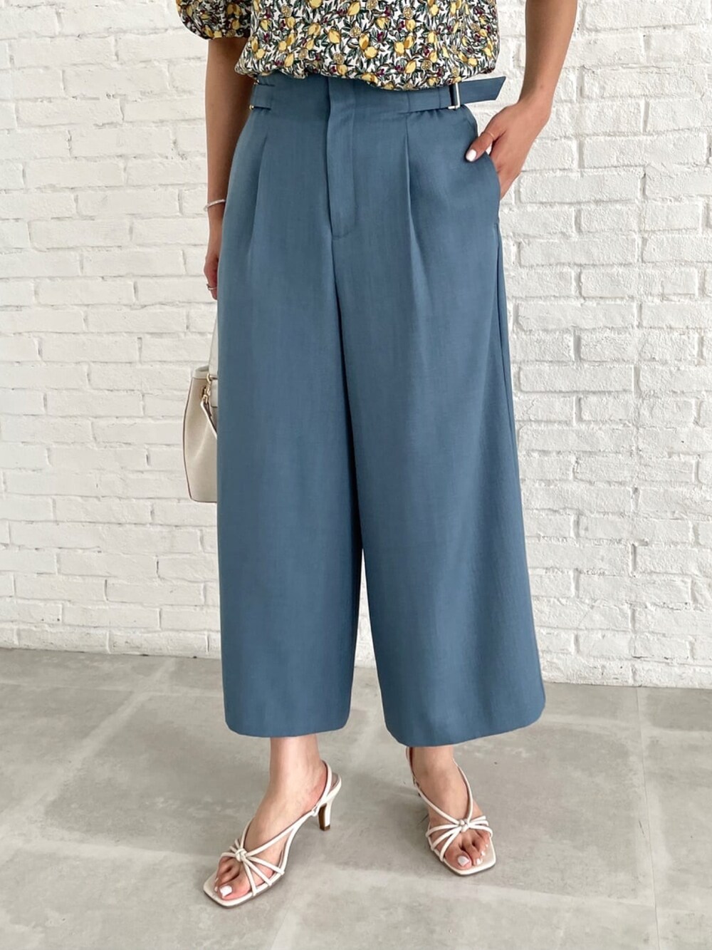 ブルー系のその他パンツ、ホワイト系のサンダル、ホワイト系のシャツ/ブラウスを着用したレディースの夏コーディネートの4枚目の写真