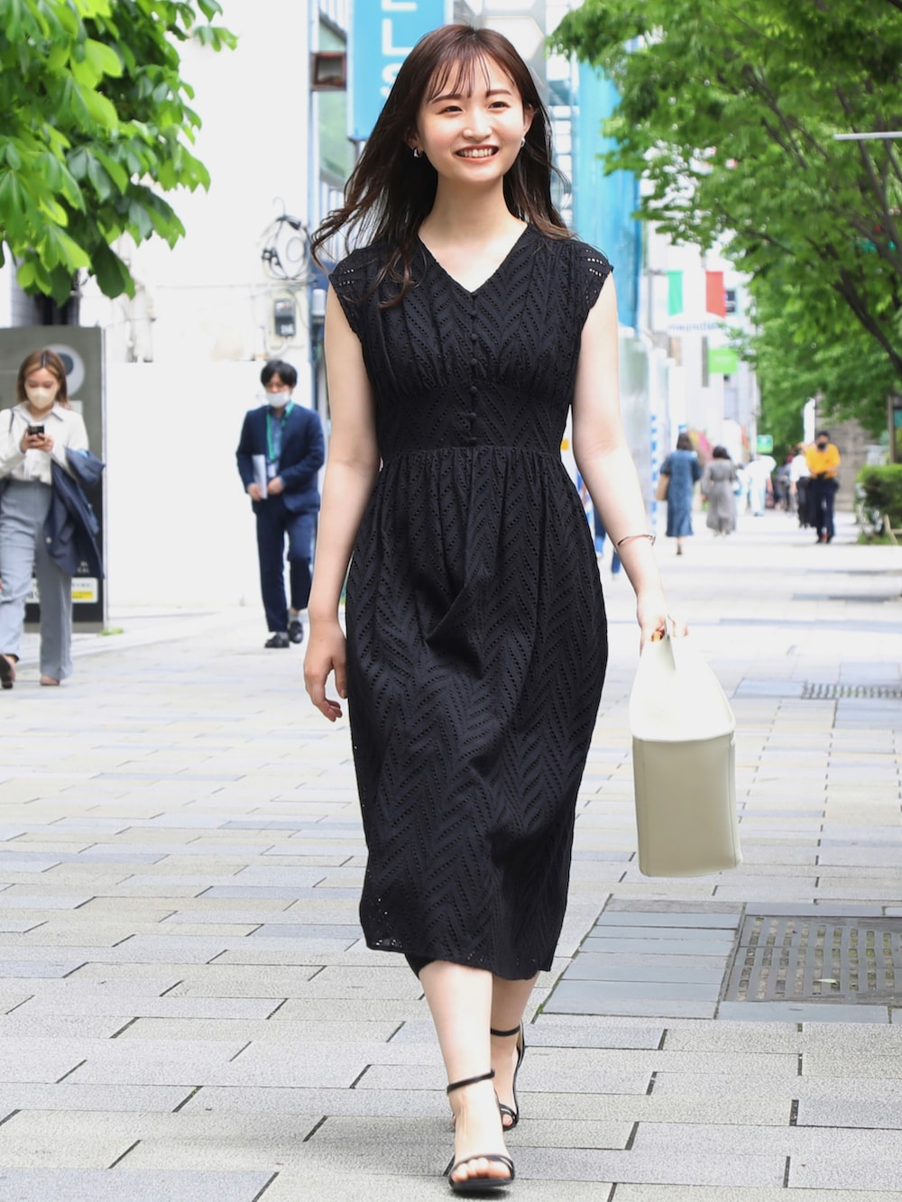 ホワイト系のカーディガン/ボレロ、ブラック系のワンピース、ブラック系のサンダルを着用したレディースの春コーディネートの3枚目の写真