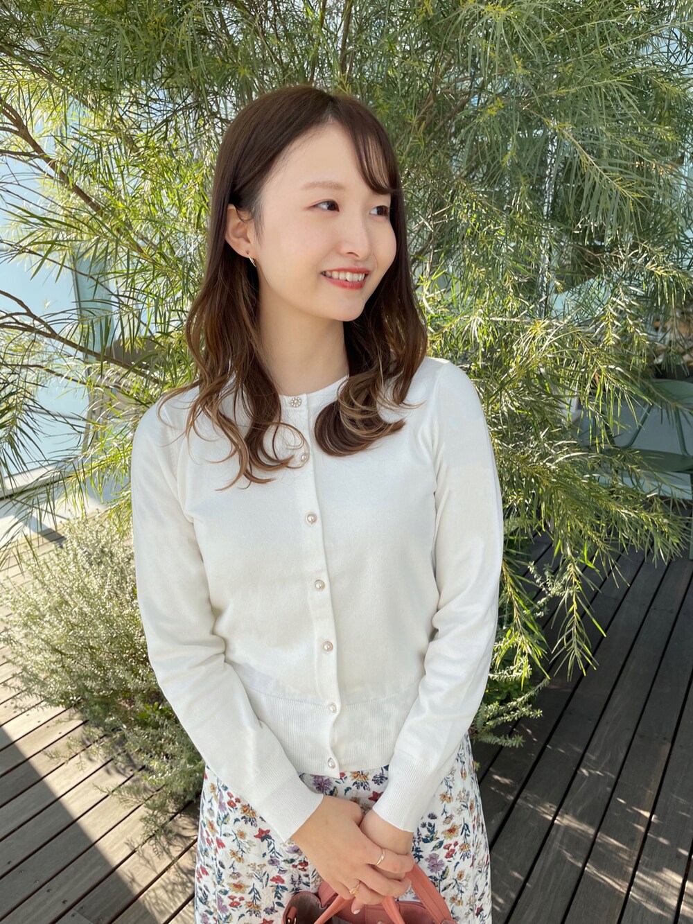 ホワイト系のカーディガン/ボレロ、ホワイト系のスカート、オレンジ系のトートバッグを着用したレディースの冬コーディネートの2枚目の写真