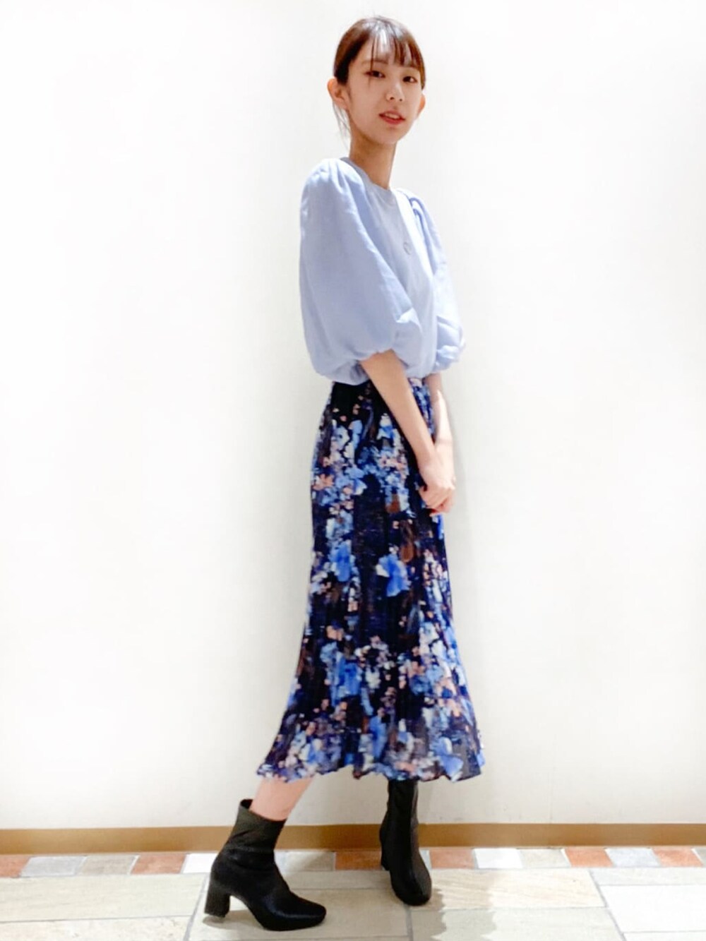 ブルー系のTシャツ/カットソー、ブルー系のスカート、ブラック系のブーツを着用したレディースの秋コーディネートの3枚目の写真