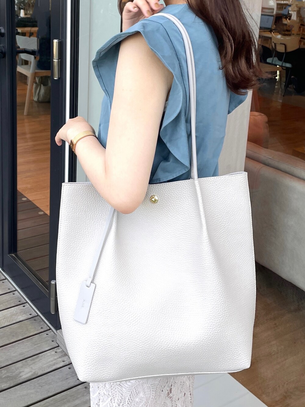 ブルー系のTシャツ/カットソー、グレー系のスカート、グレー系のトートバッグを着用したレディースの夏コーディネートの5枚目の写真