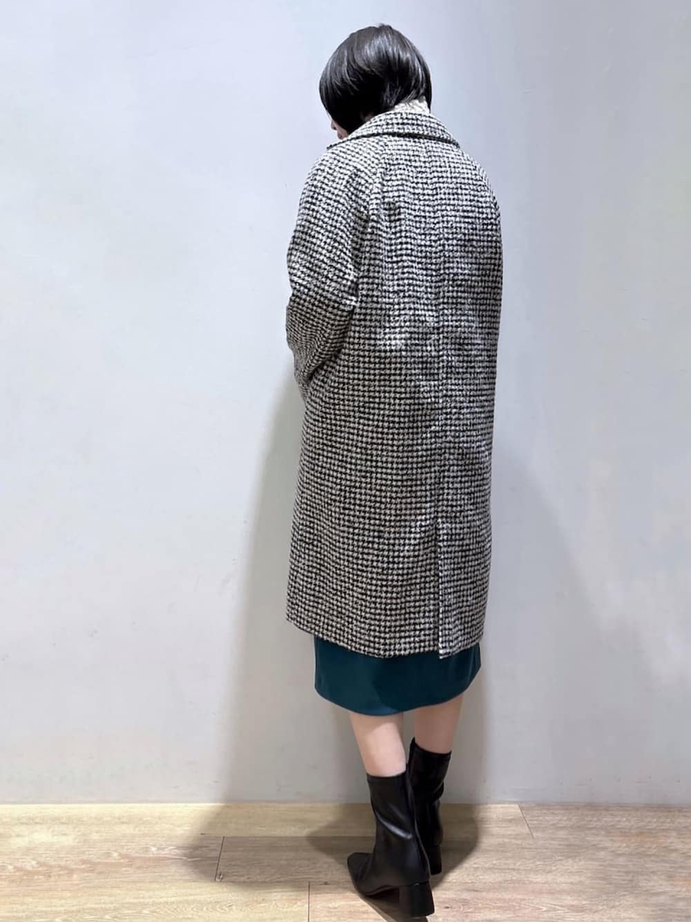 ベージュ系のニット/セーター、ブラック系のチェスターコート、ブルー系のスカートを着用したレディースの冬コーディネートの4枚目の写真