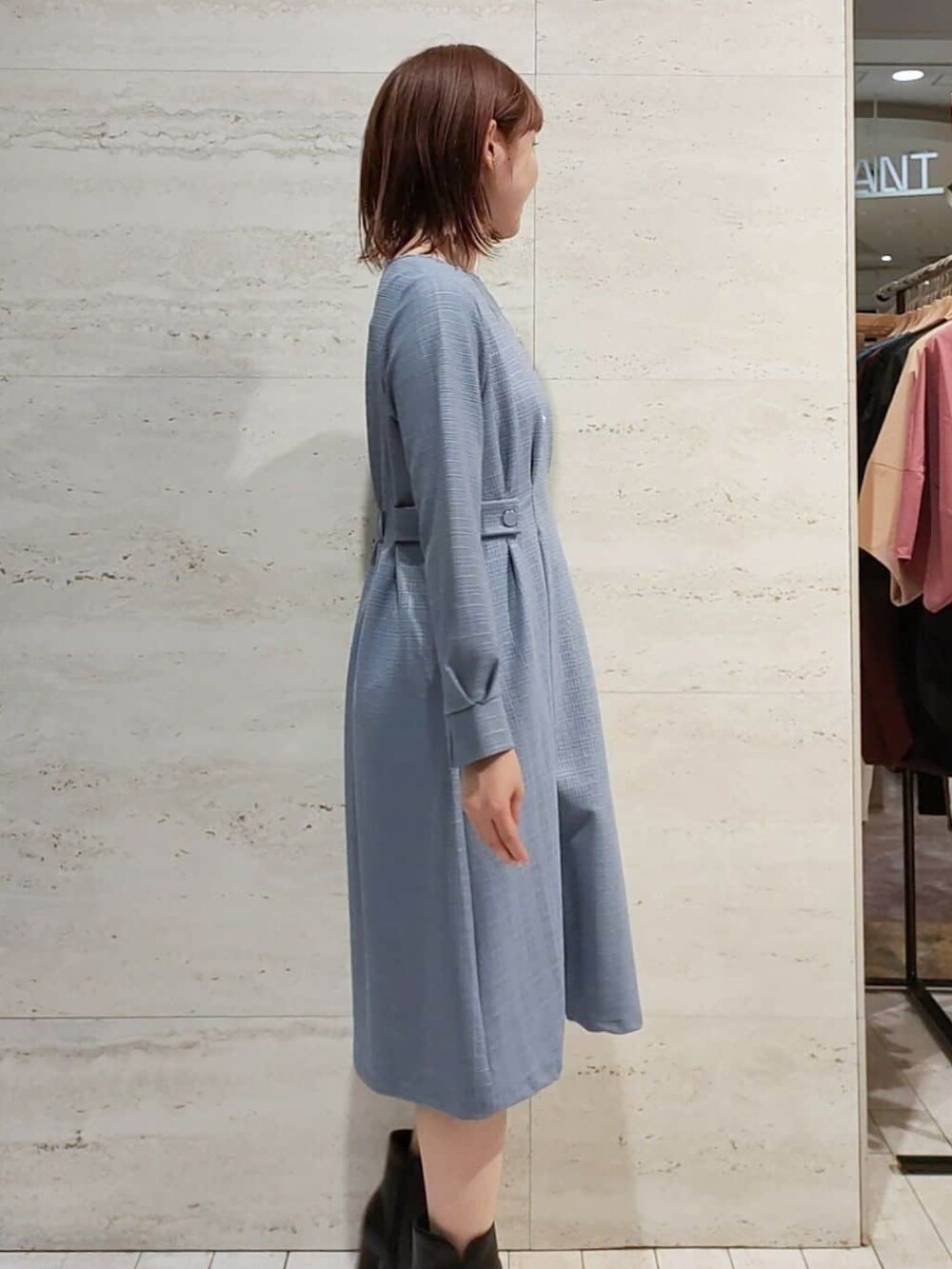 ブルー系のワンピース、シルバー系のショルダーバッグ、ブラック系のブーツを着用したレディースの秋コーディネートの2枚目の写真