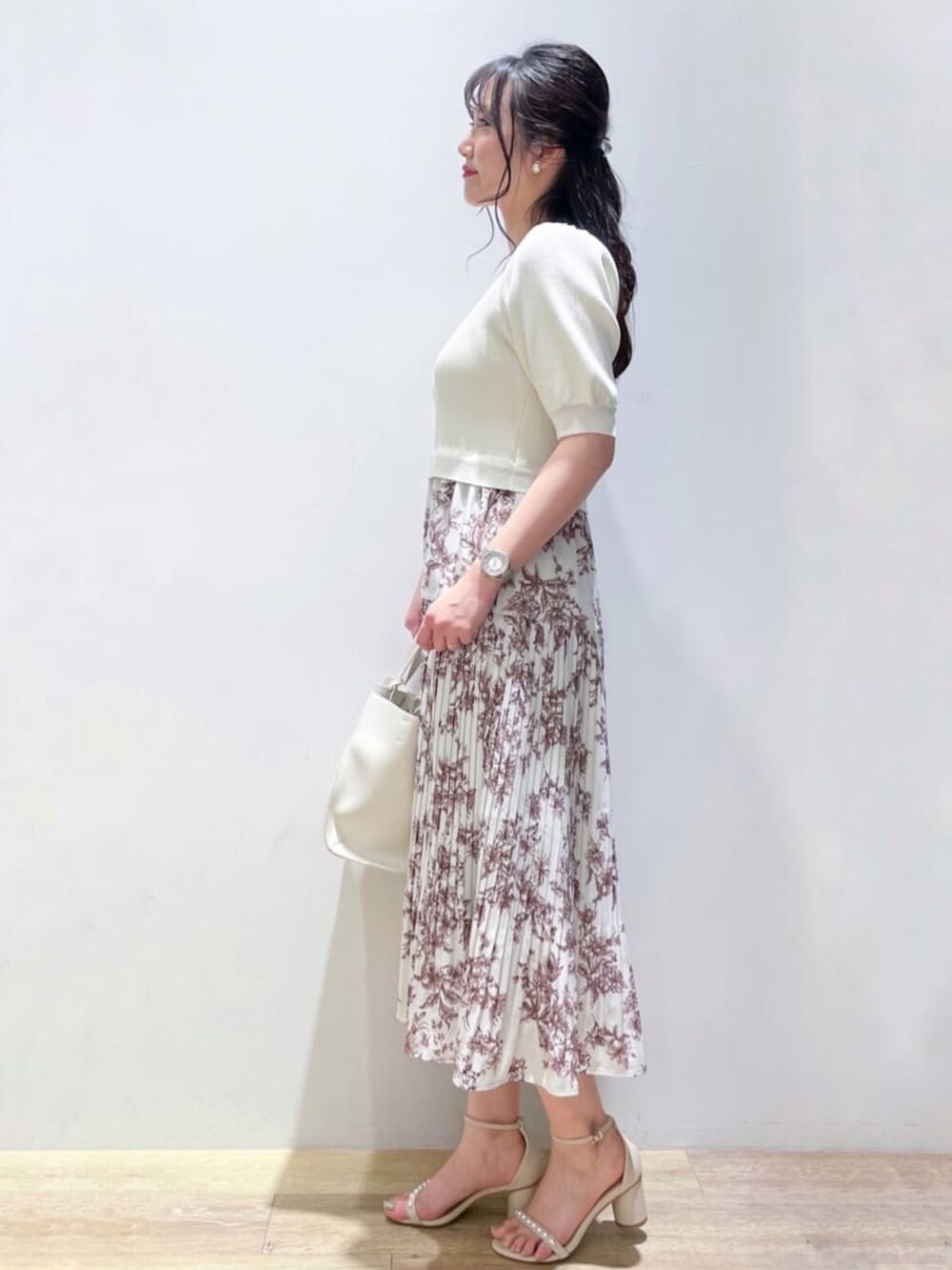 ベージュ系のサンダル、ホワイト系のワンピース、ホワイト系のトートバッグを着用したレディースの夏コーディネートの3枚目の写真