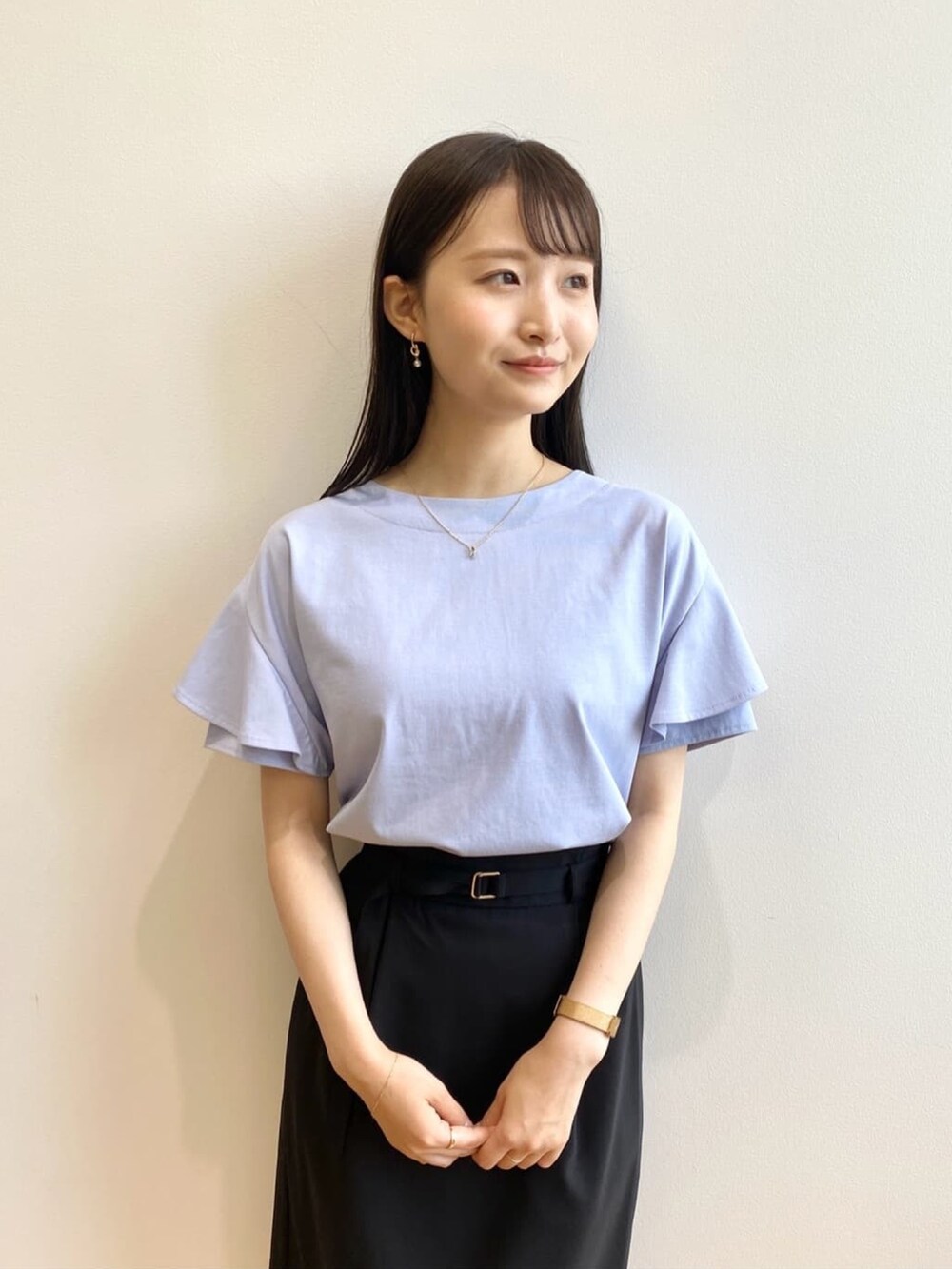 ブラック系のスカート、ブルー系のTシャツ/カットソー、ブラック系のサンダルを着用したレディースの春コーディネートの5枚目の写真