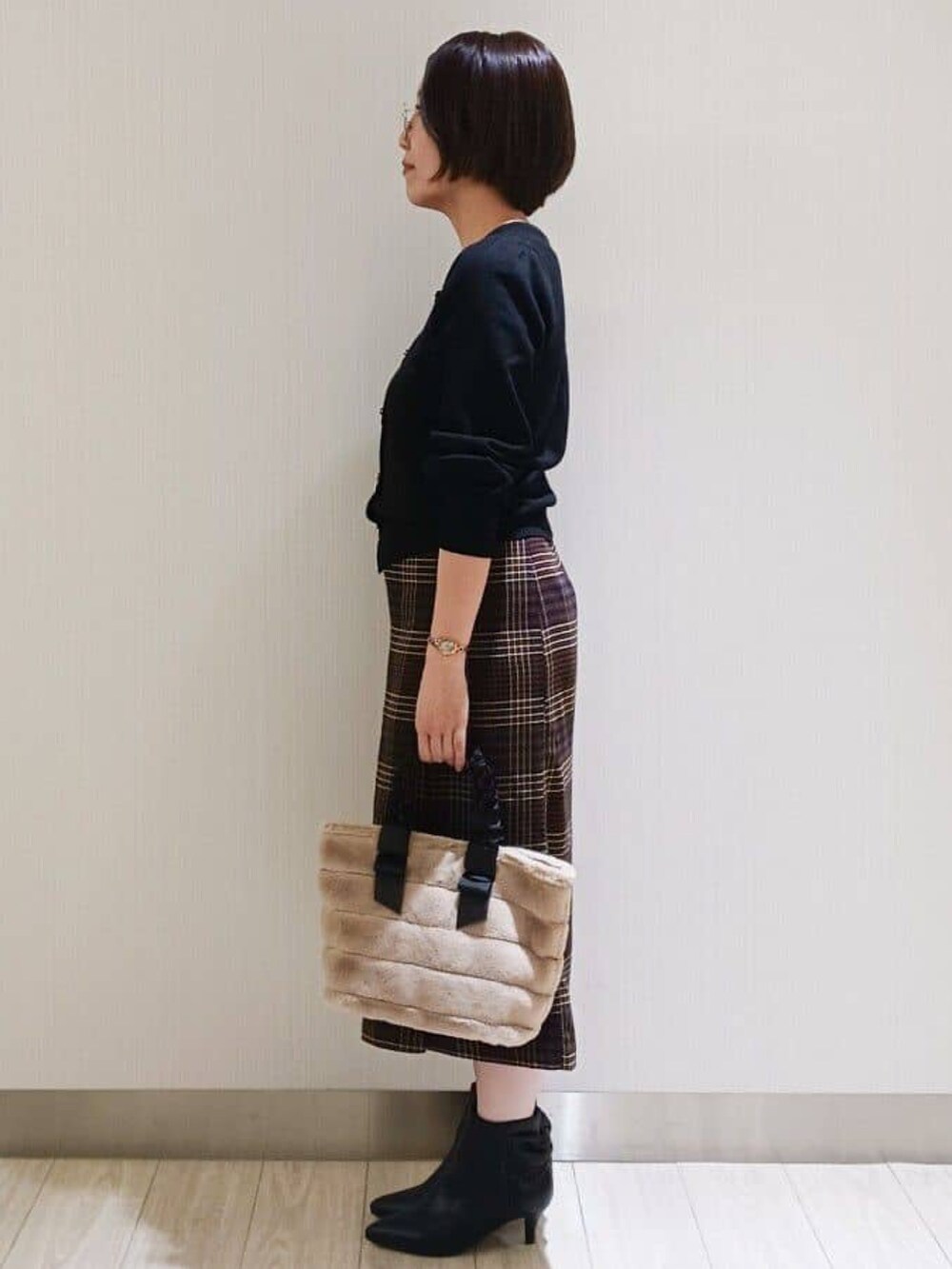ブラック系のカーディガン/ボレロ、ブラウン系のスカート、ブラック系のブーツを着用したレディースの秋コーディネートの2枚目の写真