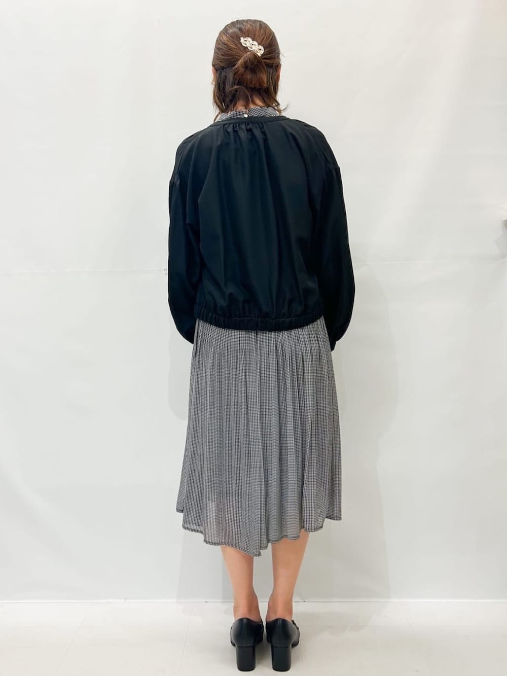 ブラック系のブルゾン、ブラック系のワンピース、ブラック系のパンプスを着用したレディースの秋コーディネートの4枚目の写真