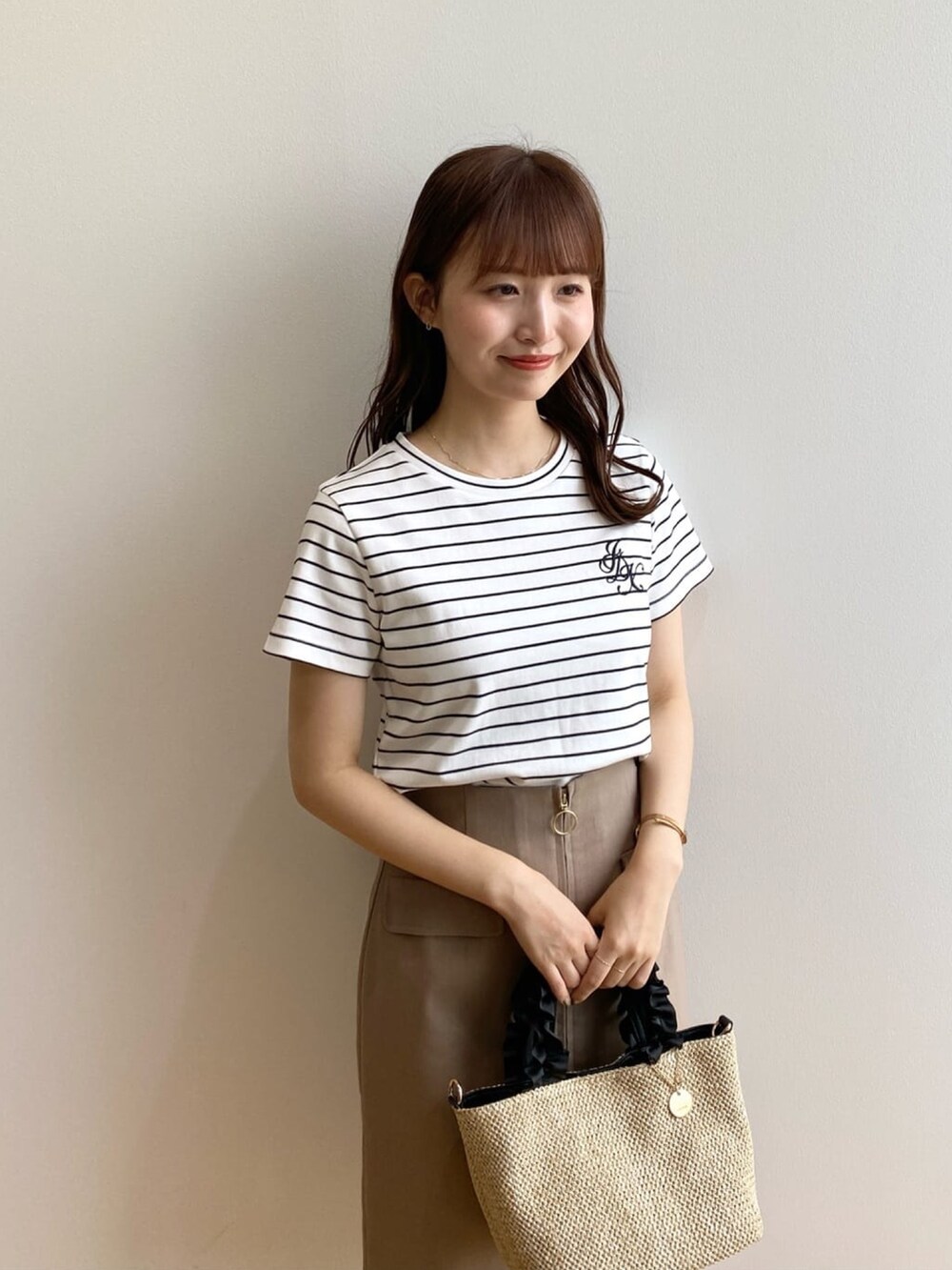 ホワイト系のTシャツ/カットソー、ブラウン系のスカート、ブラック系のトートバッグを着用したレディースの夏コーディネートの6枚目の写真