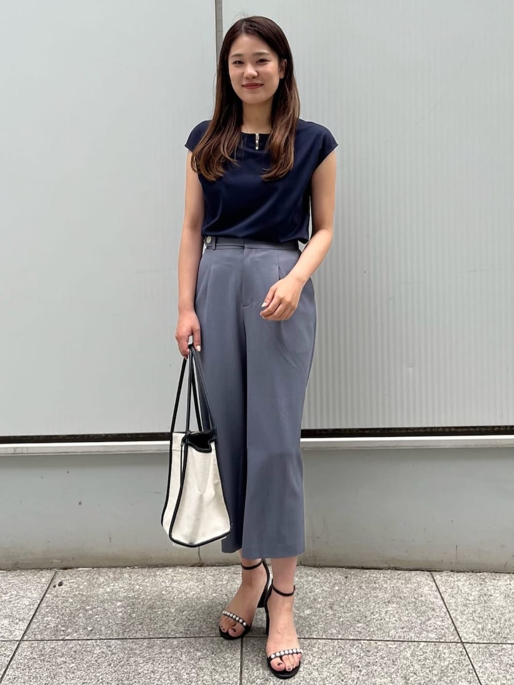 グレー系のその他パンツ、ブルー系のTシャツ/カットソー、ブラック系のサンダルを着用したレディースの春コーディネートの2枚目の写真