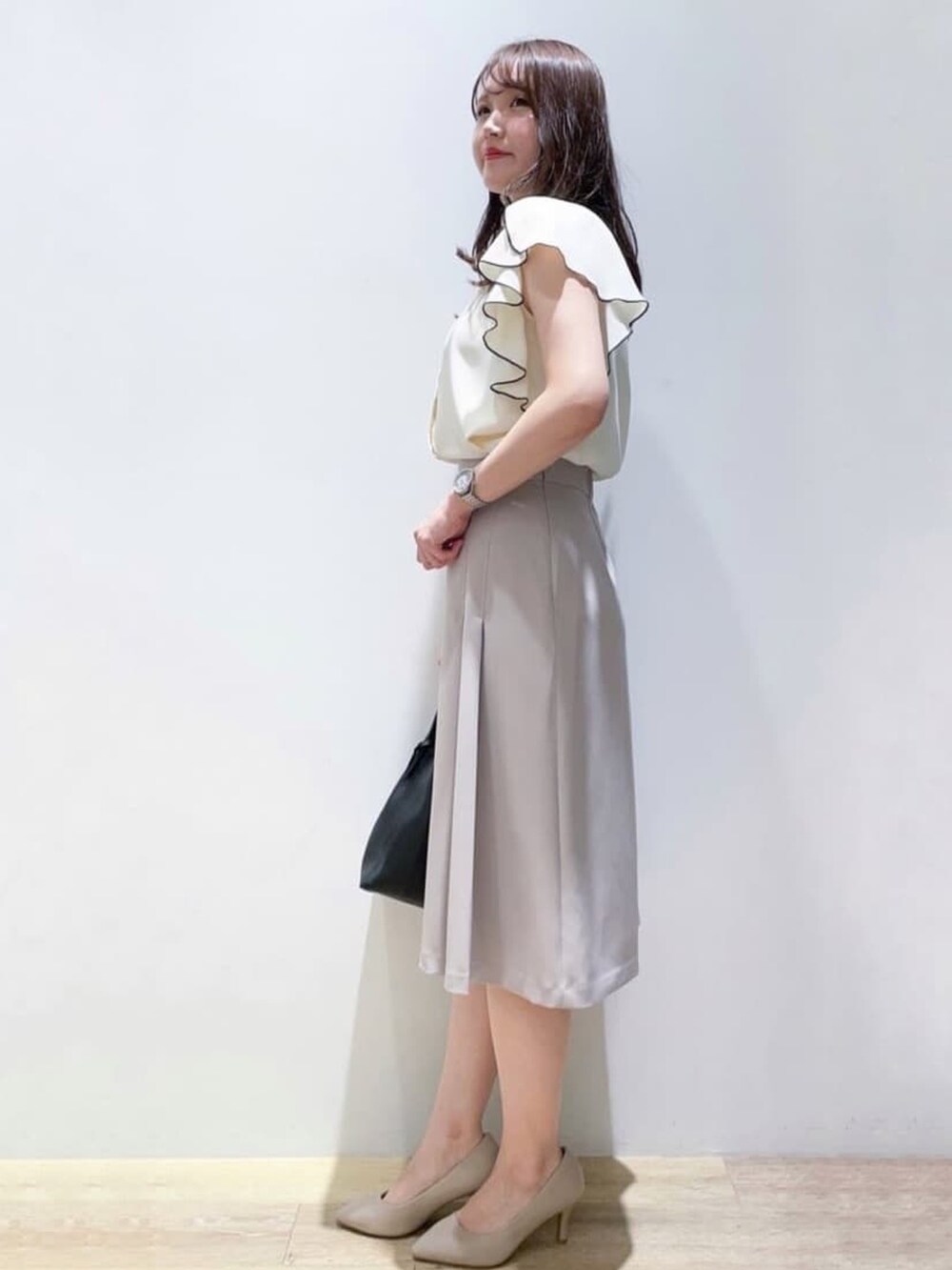 ホワイト系のシャツ/ブラウス、ベージュ系のスカート、ブラック系のトートバッグを着用したレディースの秋コーディネートの3枚目の写真