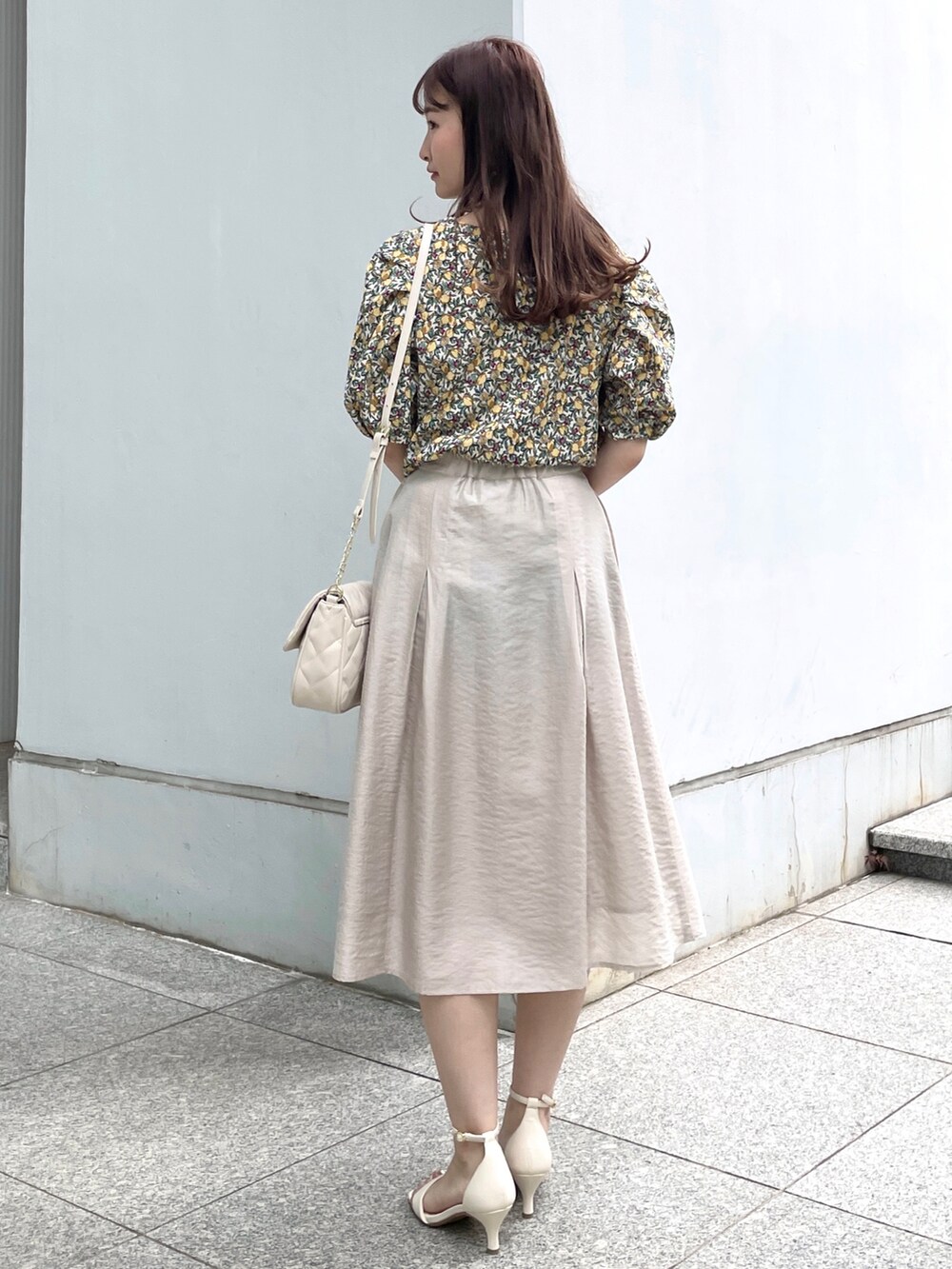 グレー系のスカート、ホワイト系のサンダル、ホワイト系のショルダーバッグを着用したレディースの夏コーディネートの3枚目の写真