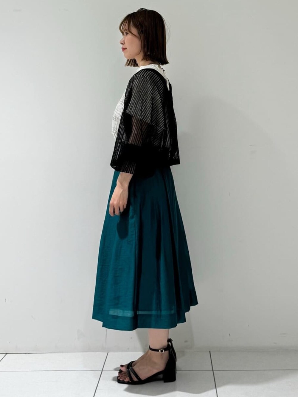 ブラック系のカーディガン/ボレロ、ベージュ系のシャツ/ブラウス、グリーン系のスカートを着用したレディースの夏コーディネートの2枚目の写真