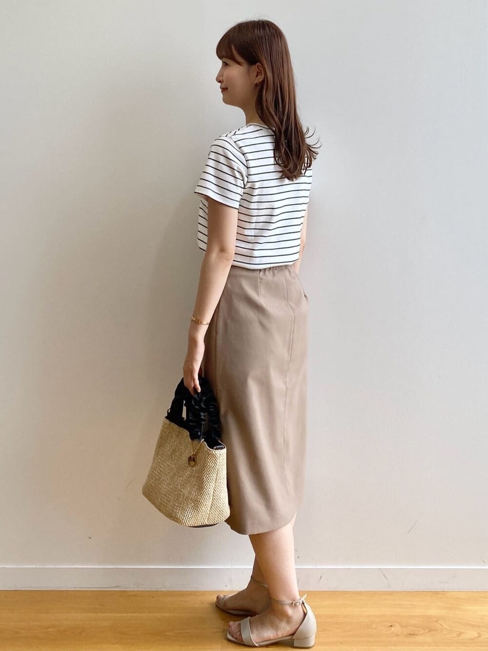 ホワイト系のTシャツ/カットソー、ブラウン系のスカート、ブラック系のトートバッグを着用したレディースの夏コーディネートの5枚目の写真
