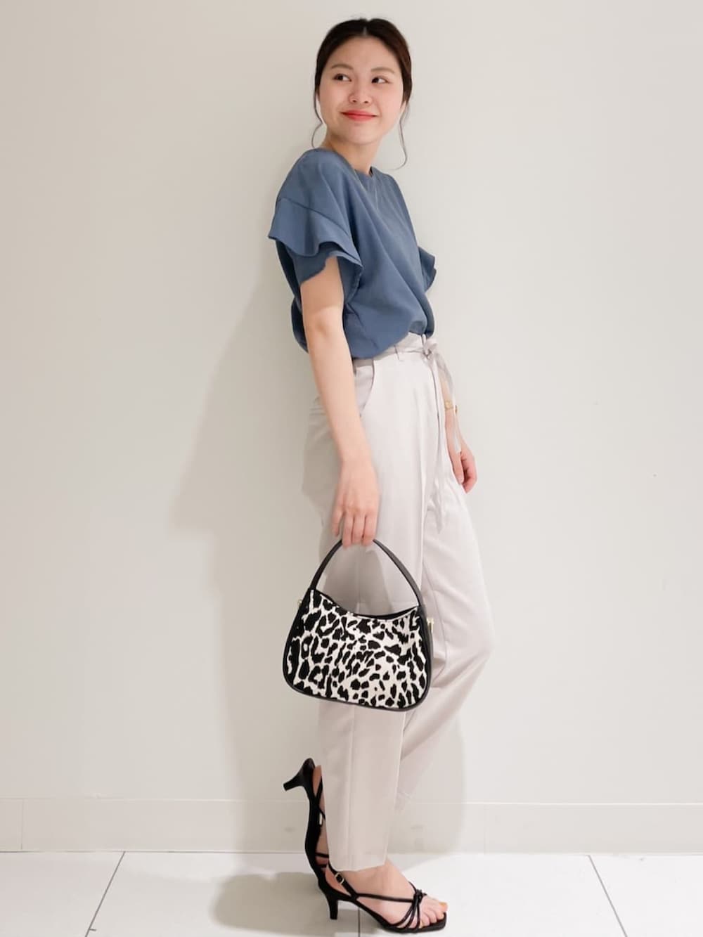 ブルー系のシャツ/ブラウス、グレー系のその他パンツ、ブラック系のショルダーバッグを着用したレディースの夏コーディネートの2枚目の写真