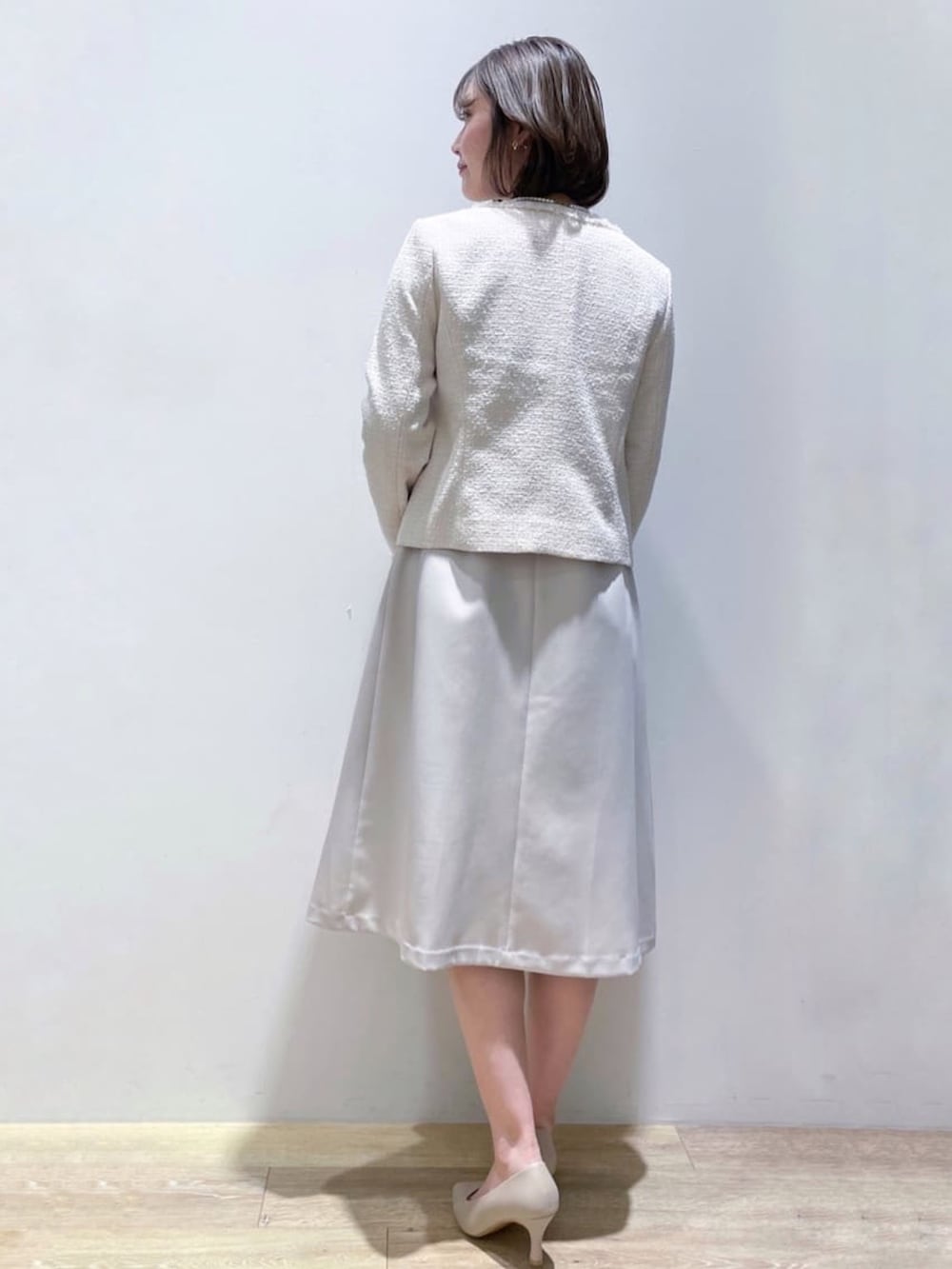 ベージュ系のワンピース、グレー系のショルダーバッグ、ベージュ系のパンプスを着用したレディースの冬コーディネートの3枚目の写真