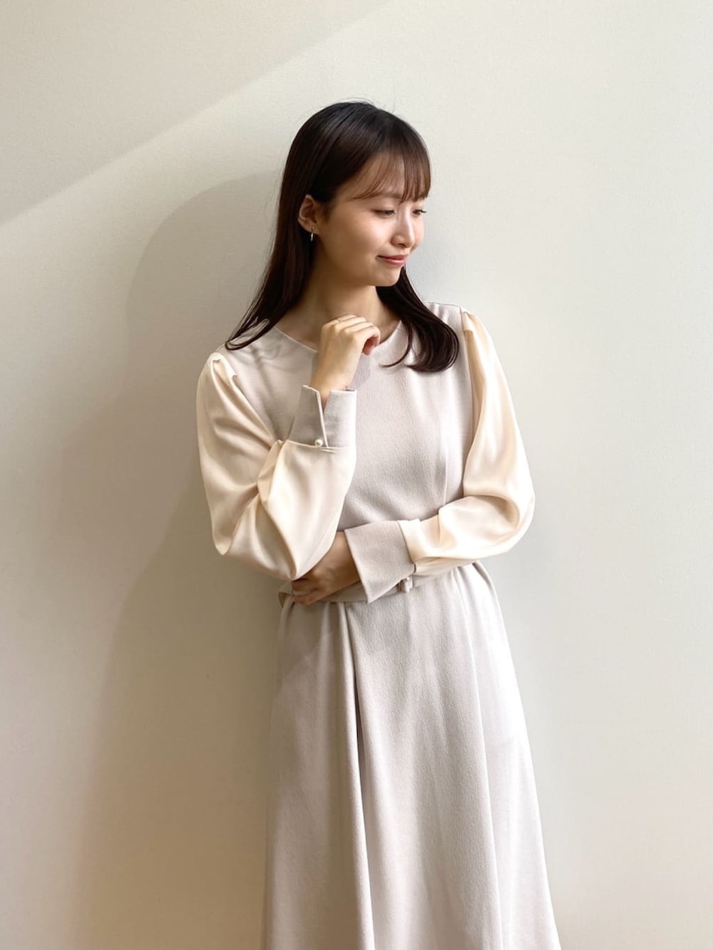 ベージュ系のワンピース、ホワイト系のパンプスを着用したレディースの冬コーディネートの5枚目の写真