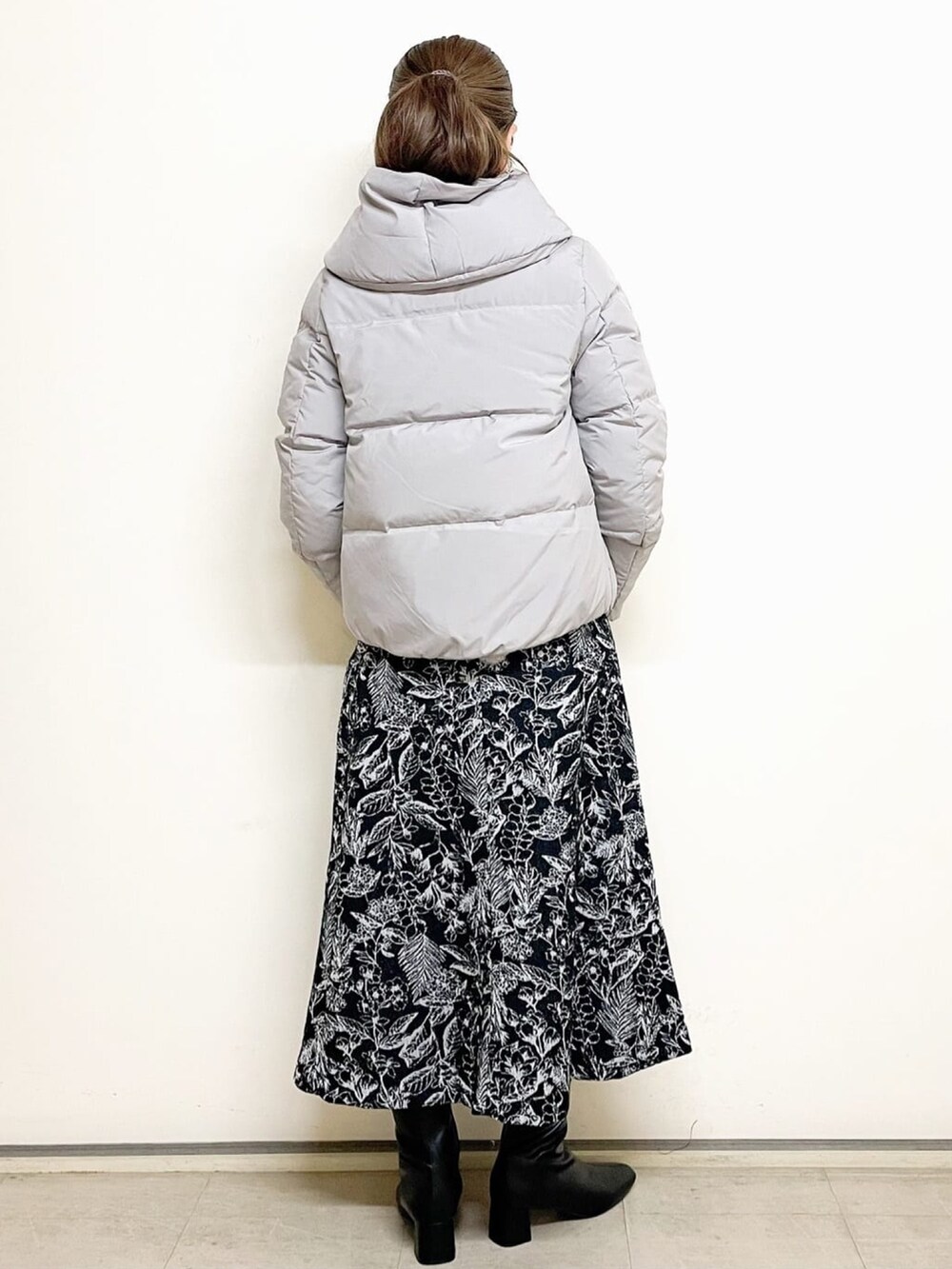 ブラウン系のニット/セーター、グレー系のダウンジャケット/コート、ブラック系のスカートを着用したレディースの冬コーディネートの3枚目の写真