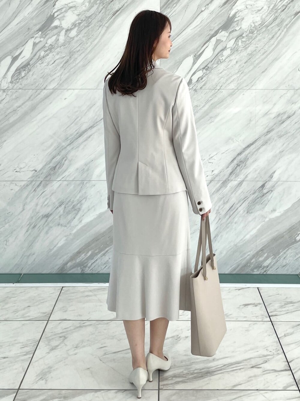 グレー系のスカート、ベージュ系のトートバッグ、ホワイト系のシャツ/ブラウスを着用したレディースの冬コーディネートの3枚目の写真