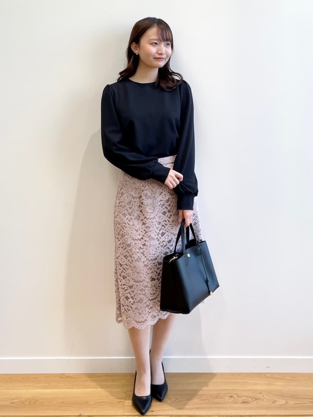 ブラック系のTシャツ/カットソー、ベージュ系のスカート、ブラック系のパンプスを着用したレディースの冬コーディネートの6枚目の写真