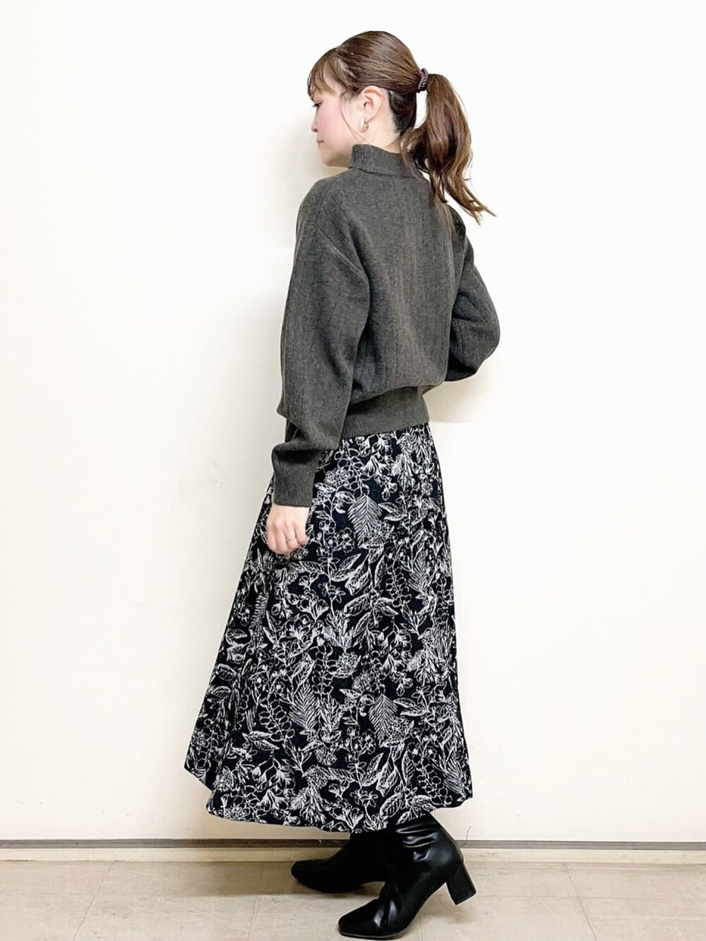 ブラウン系のニット/セーター、ブラック系のスカート、ブラック系のトートバッグを着用したレディースの冬コーディネートの4枚目の写真