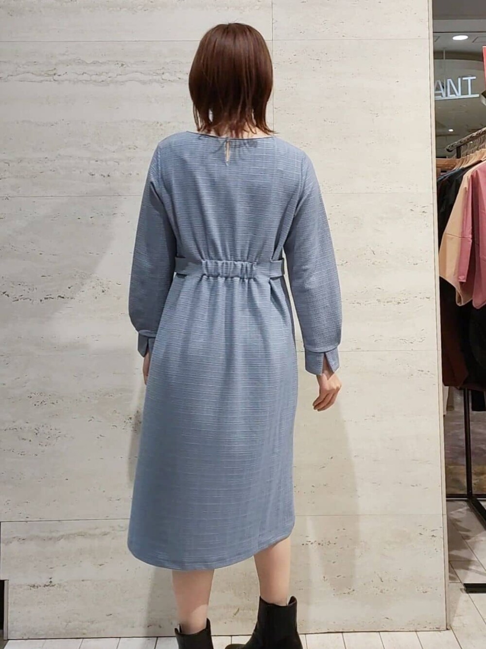 ブルー系のワンピース、シルバー系のショルダーバッグ、ブラック系のブーツを着用したレディースの秋コーディネートの3枚目の写真