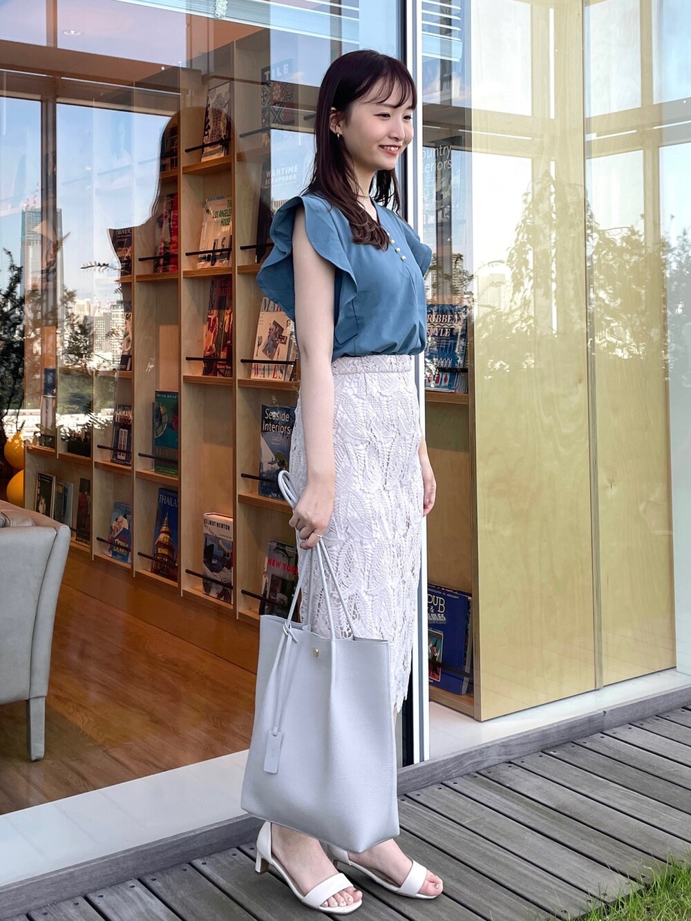 ブルー系のTシャツ/カットソー、グレー系のスカート、グレー系のトートバッグを着用したレディースの夏コーディネートの3枚目の写真