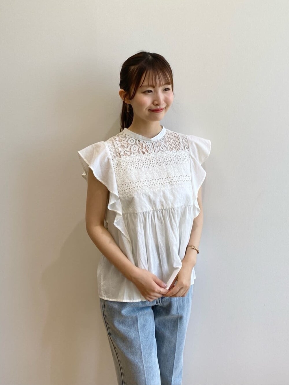 ブルー系のデニムパンツ、ベージュ系のサンダル、ホワイト系のシャツ/ブラウスを着用したレディースの夏コーディネートの7枚目の写真